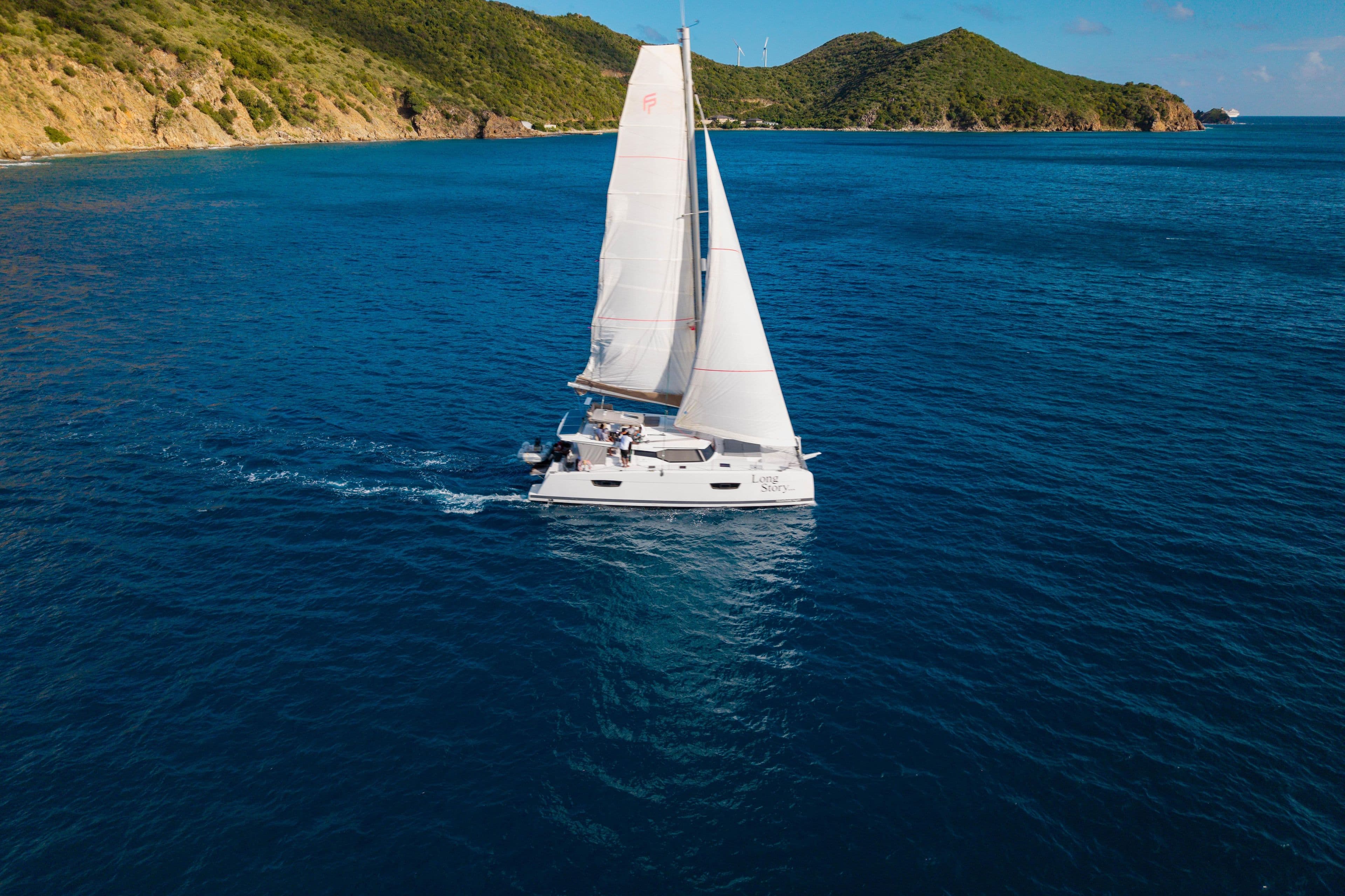 2019 Fountaine Pajot Saona 47 sailing near lush green islands.