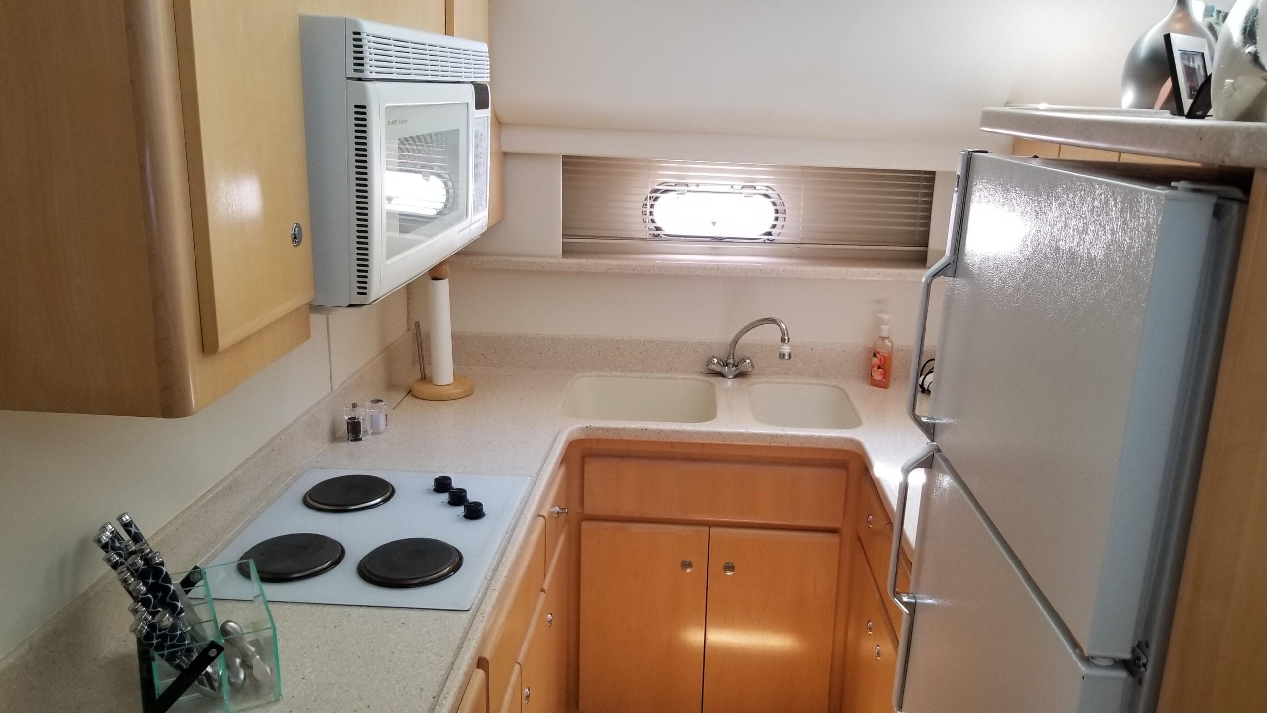 1998 Carver 445 Aft Cabin Motor Yacht kitchen with stove, microwave, and fridge.