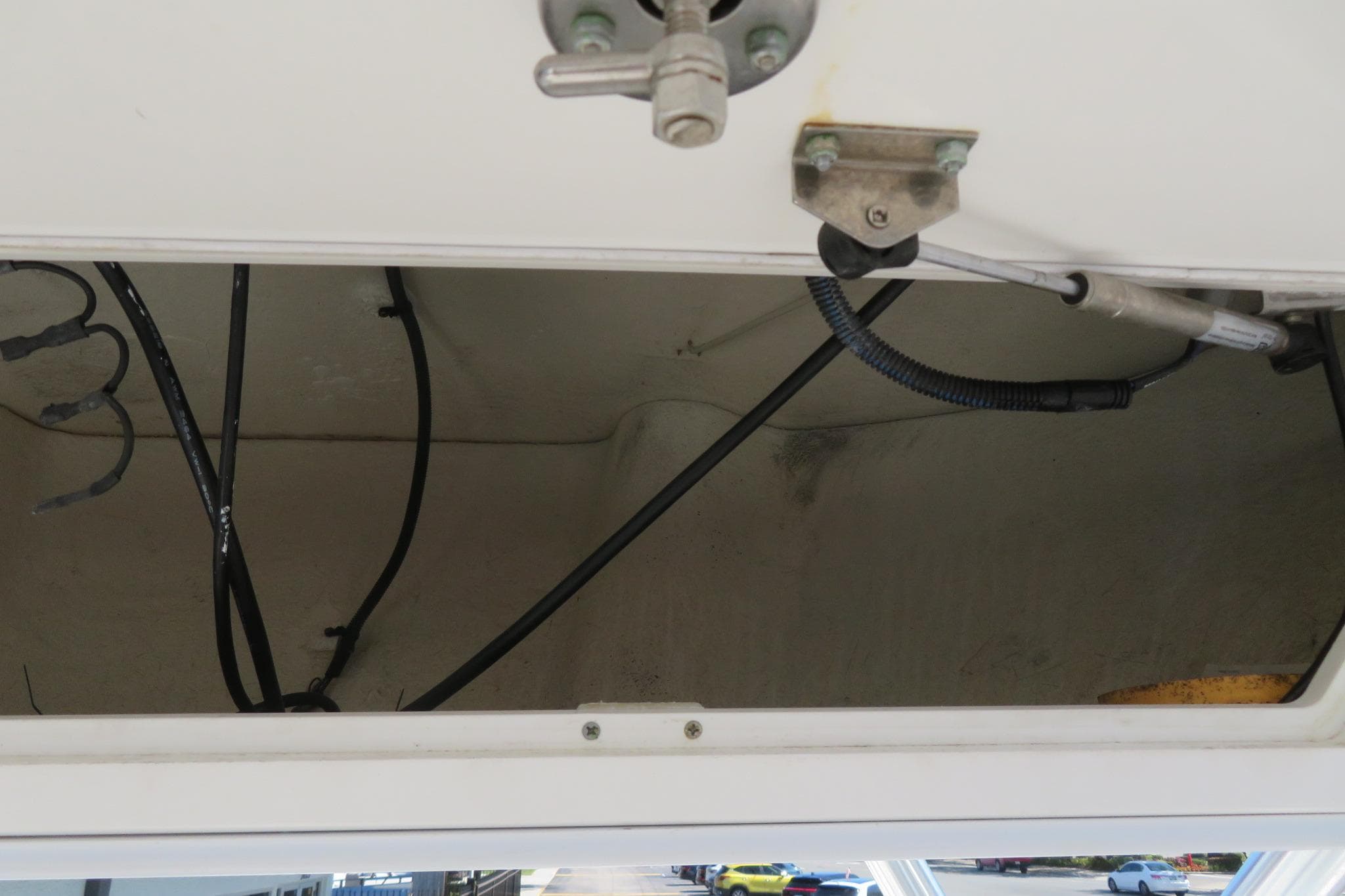 Open storage compartment in a 2017 Sea Fox 256 Voyager boat, showing wiring and fittings.