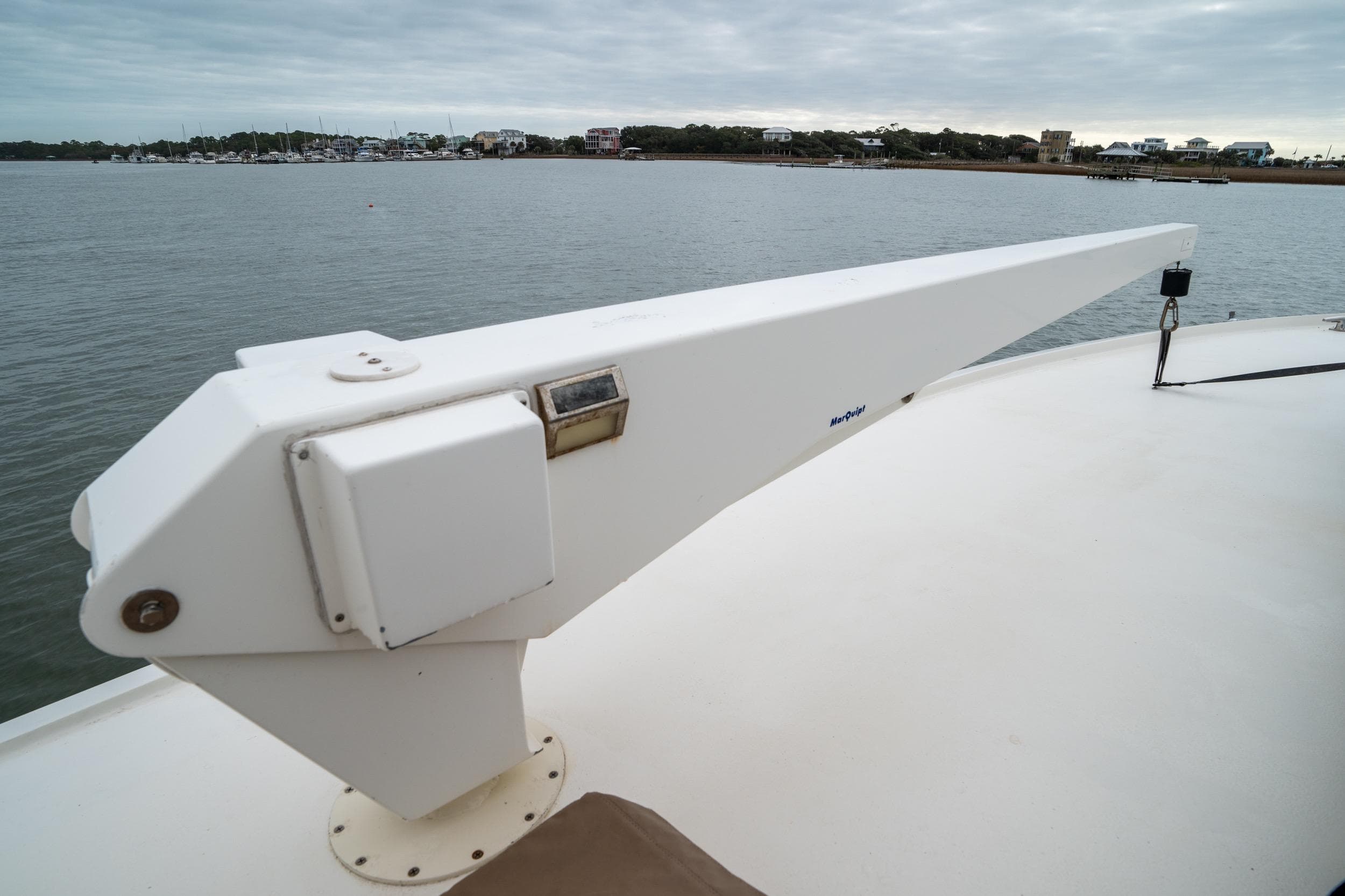 1984 Hatteras 52 Convertible yacht deck with davit, overlooking calm waters.