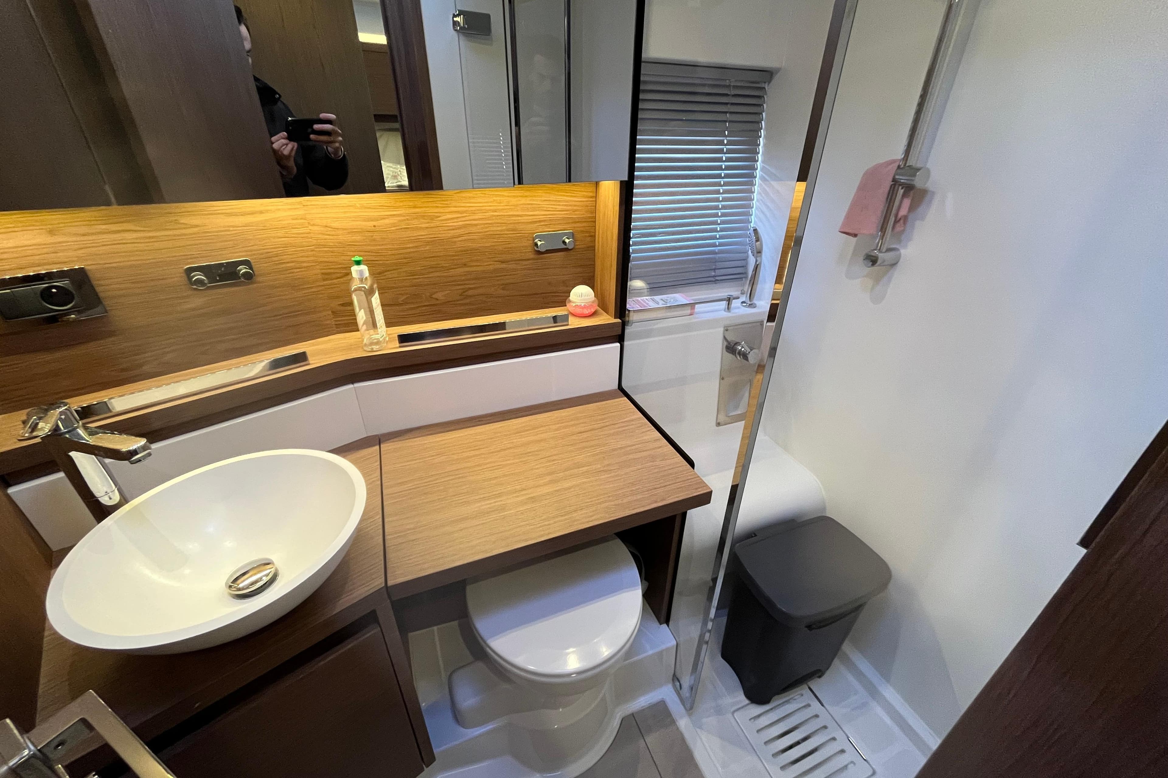 Modern bathroom in a 2016 Jeanneau Leader 46 yacht, featuring sleek wood accents and compact design.