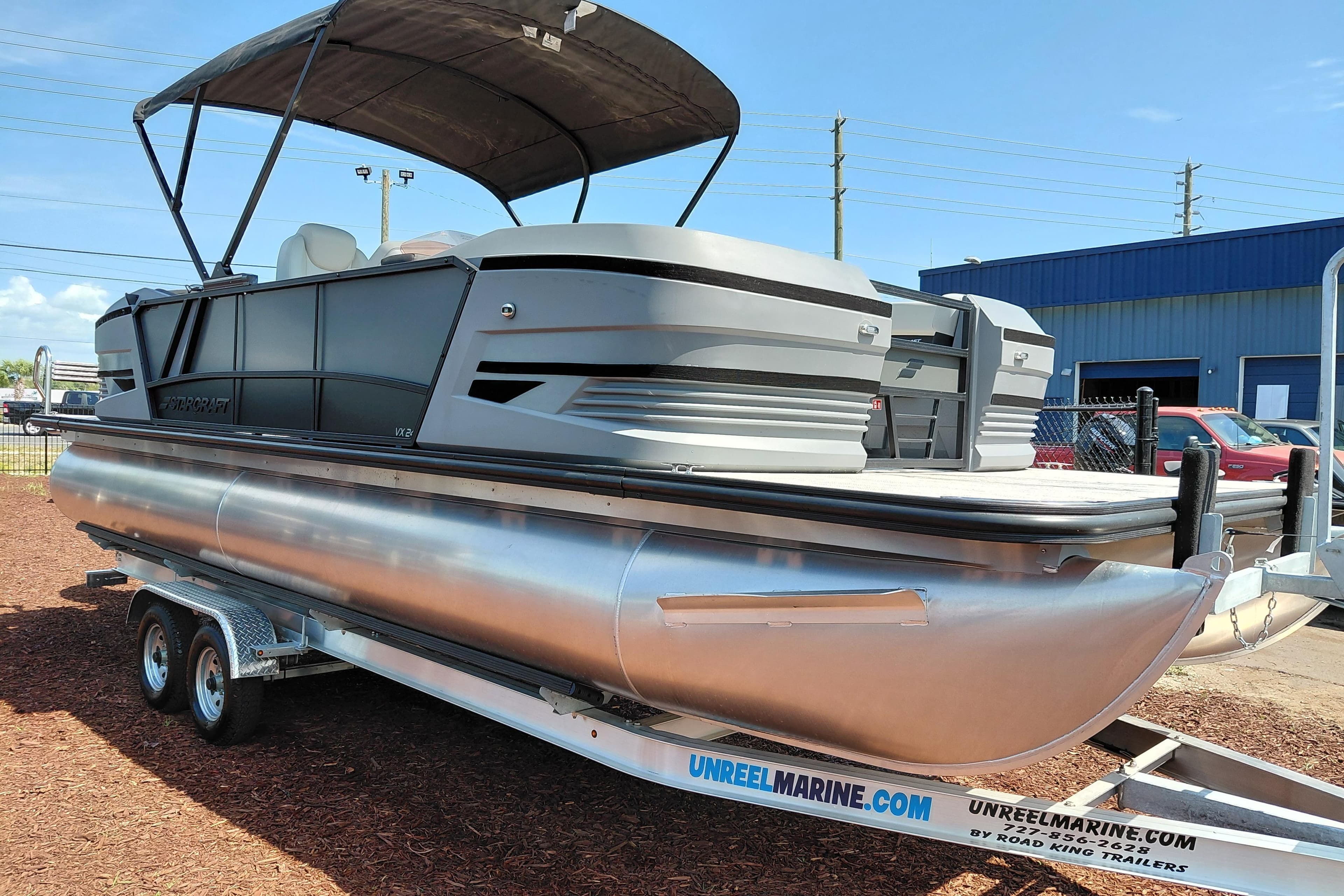2026 Starcraft VX 24 Q DH pontoon boat on trailer, parked outdoors.