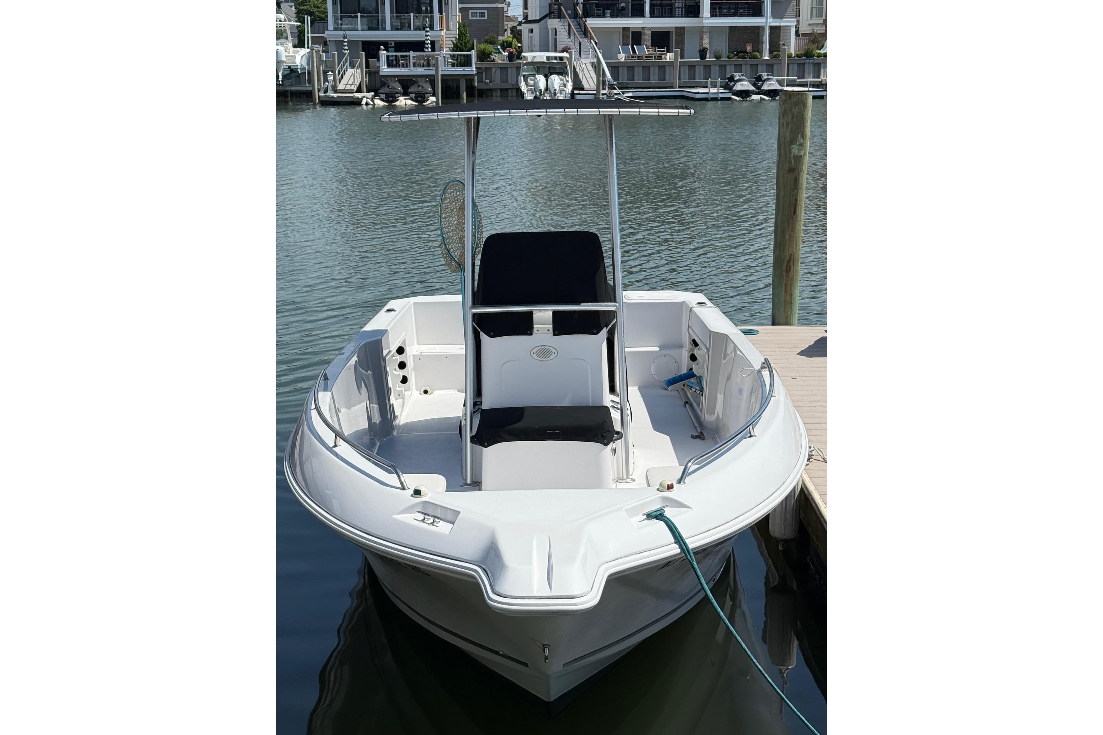 2013 Pro-Line 23 Sport boat docked at marina, featuring sleek design and spacious deck.