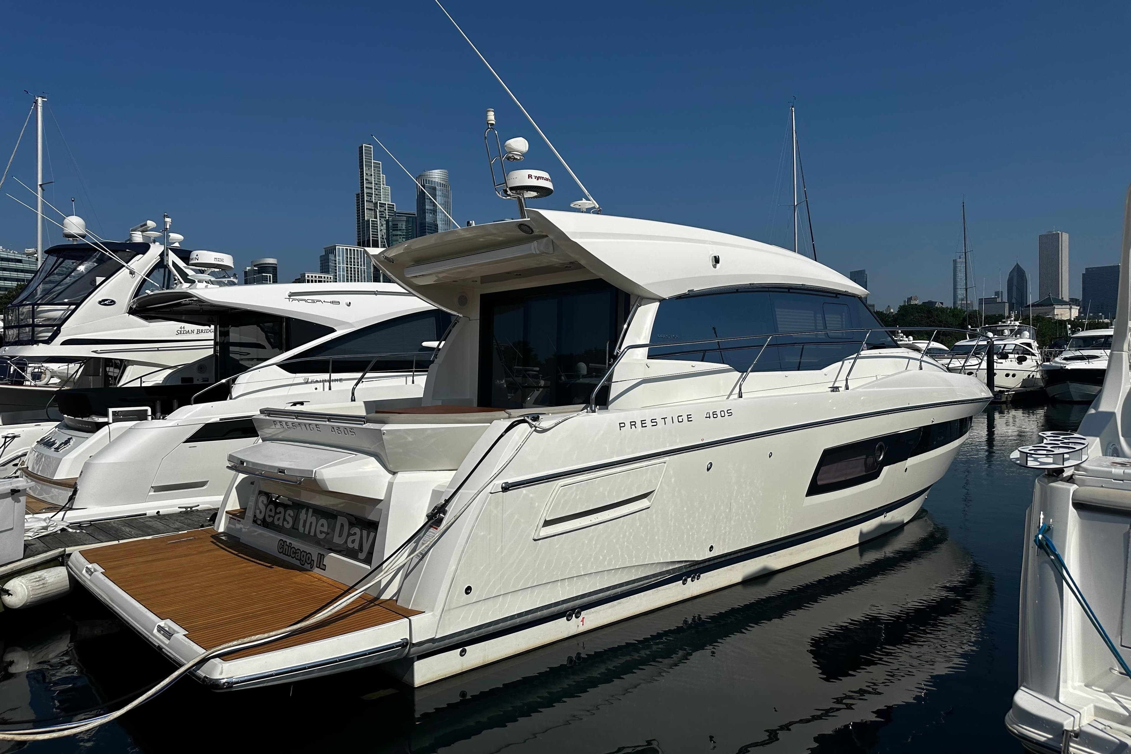 Luxury 2018 Prestige 460 yacht docked in marina, city skyline in background.