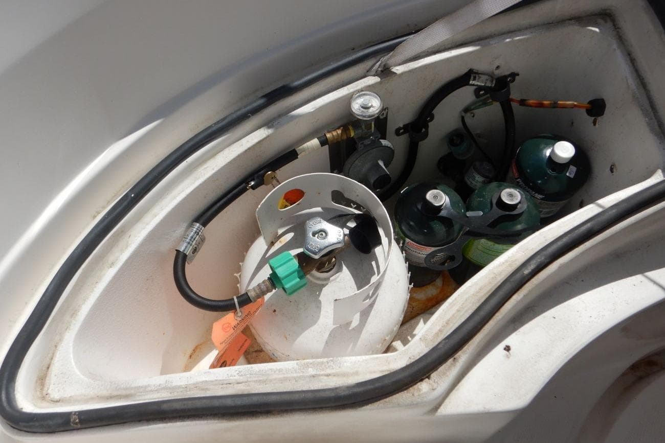 Propane storage compartment in a 2001 Hunter 320 sailboat, featuring multiple gas cylinders.