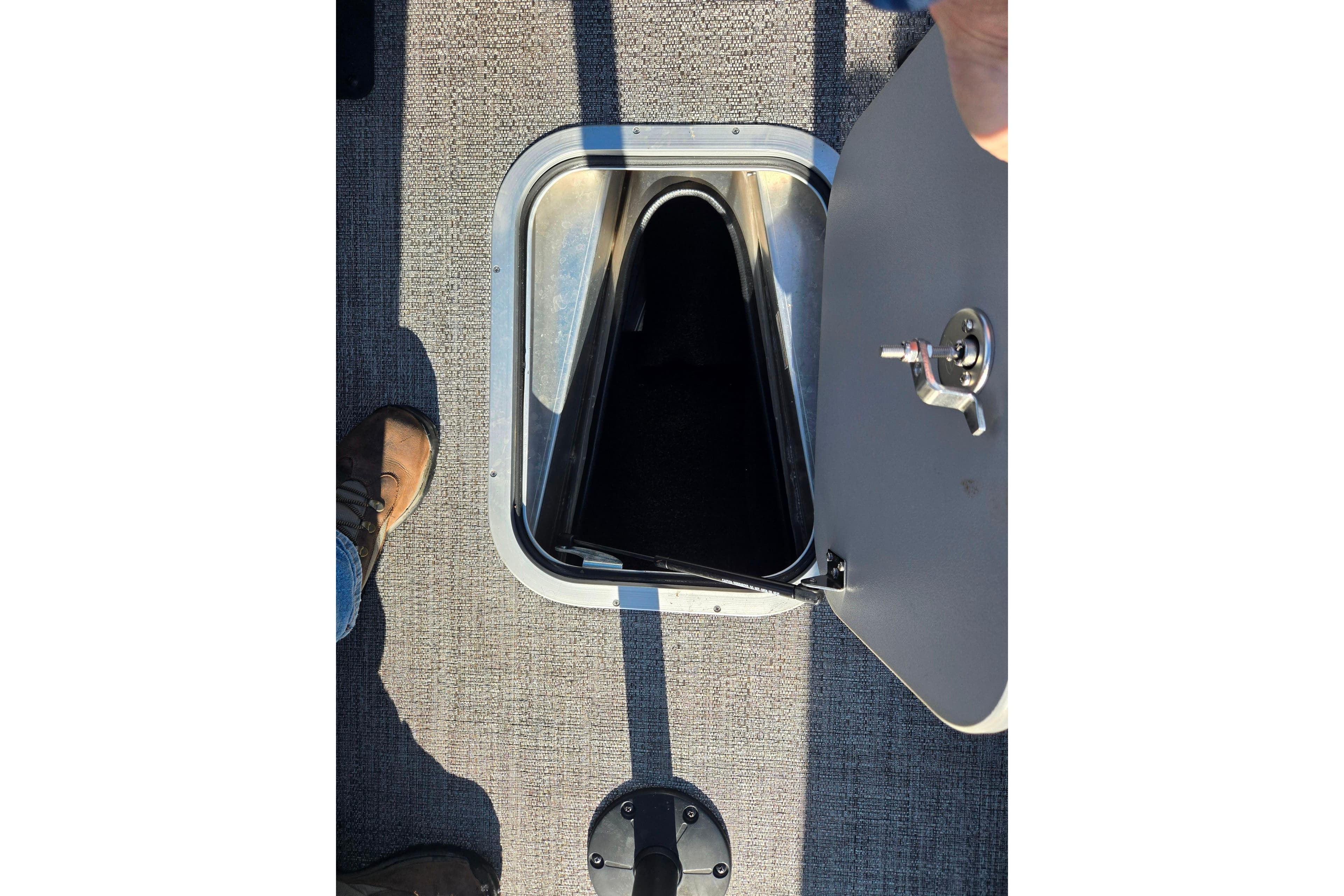 2023 Barletta Corsa 23UC boat storage compartment with open hatch on textured flooring.
