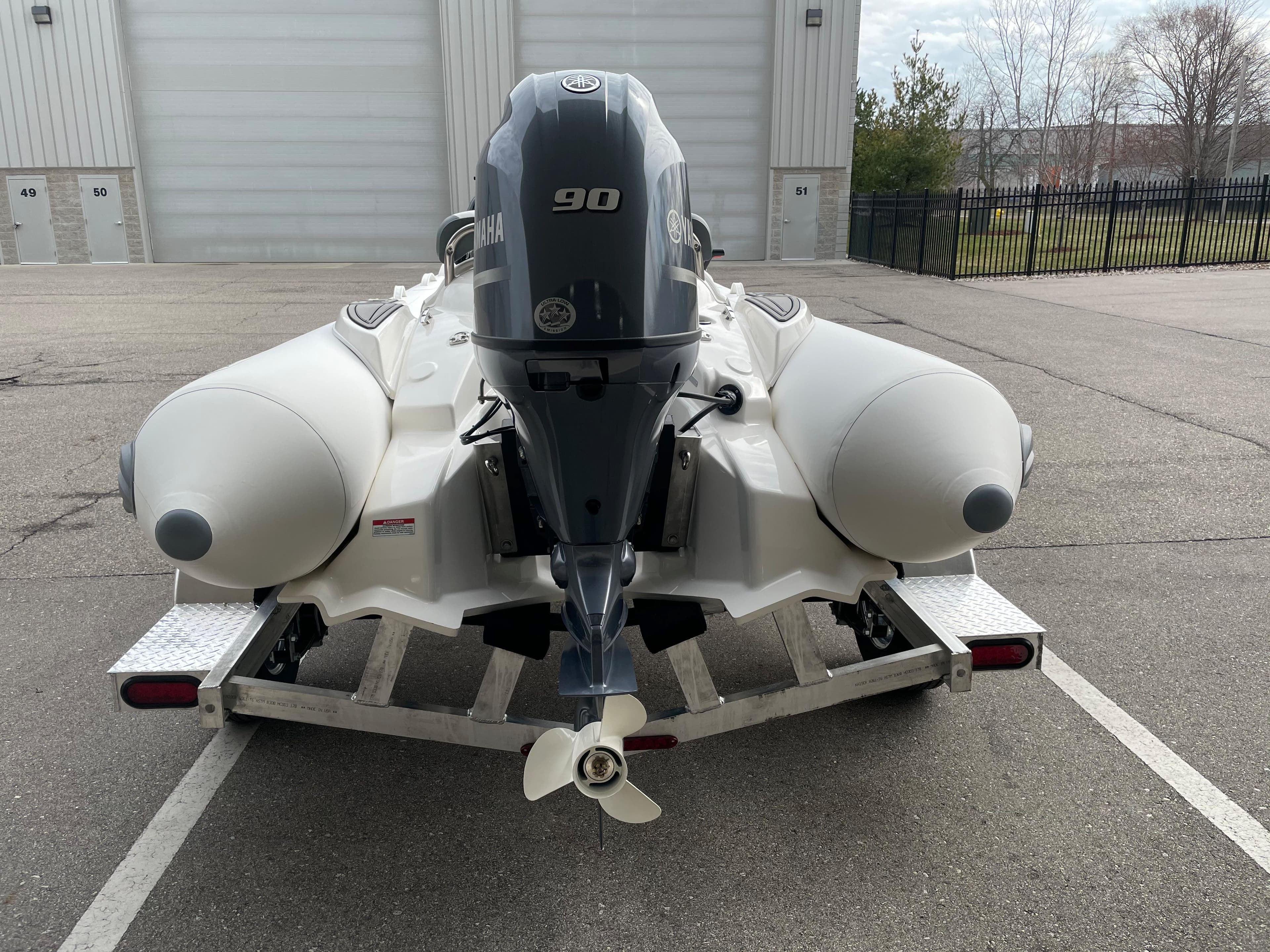 2023 Zodiac Yachtline 490 Deluxe NEO 90hp on trailer, rear view.