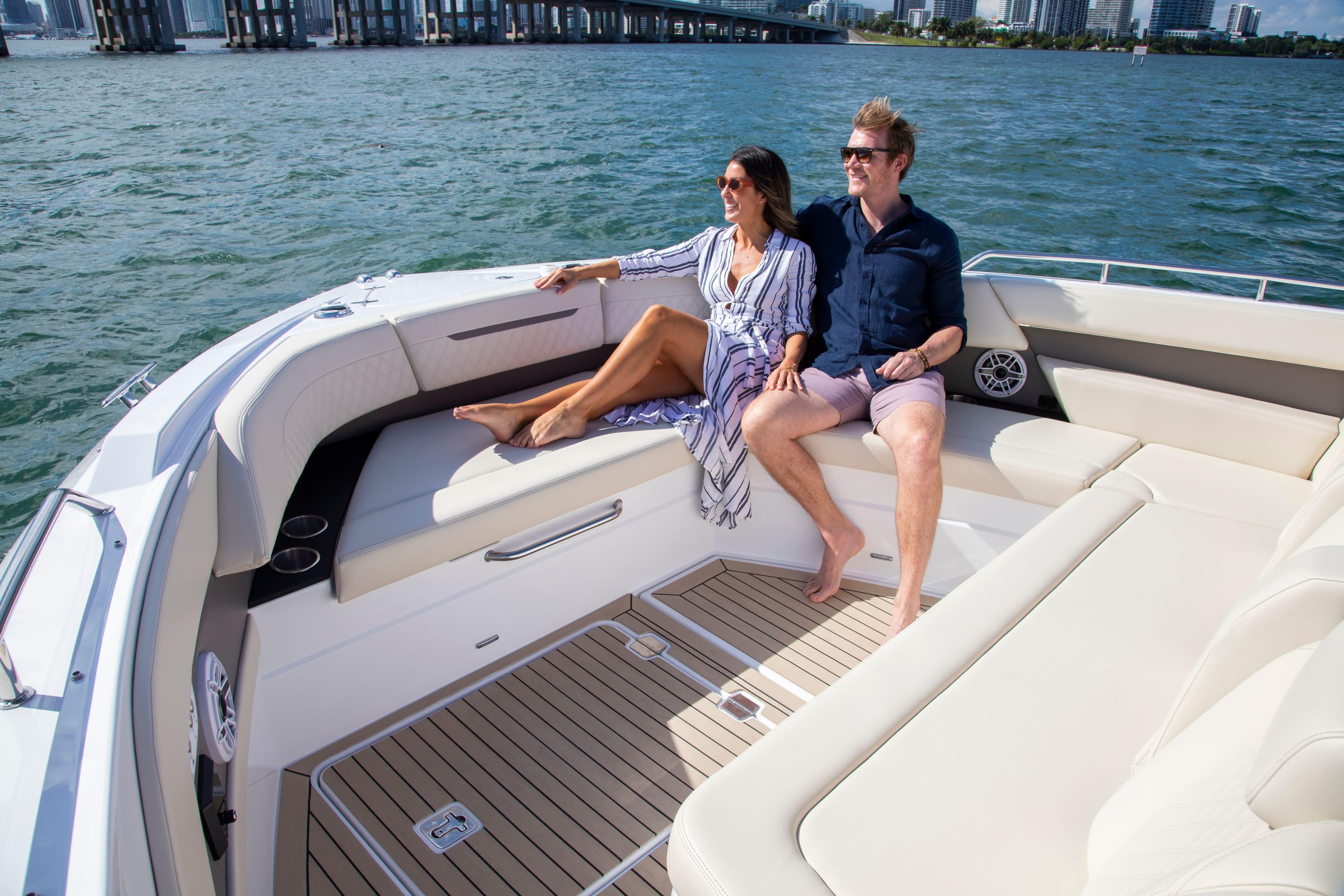 Couple relaxing on 2026 Cruisers Yachts 50 GLS, enjoying a sunny day on the water.