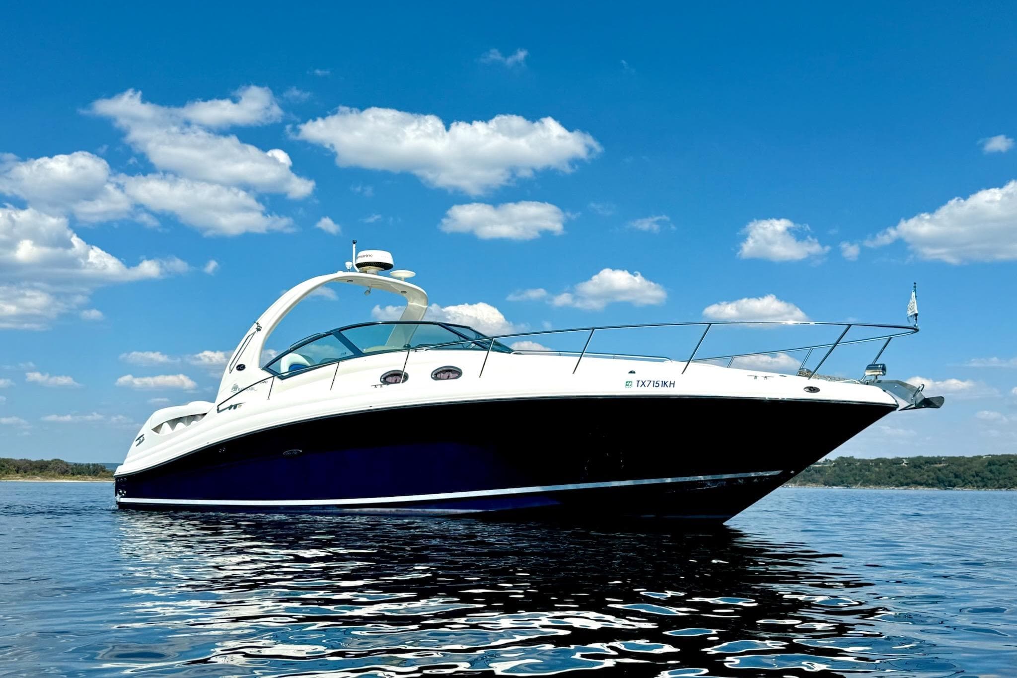 2005 Sea Ray 340 Sundancer yacht on calm water under a clear blue sky.