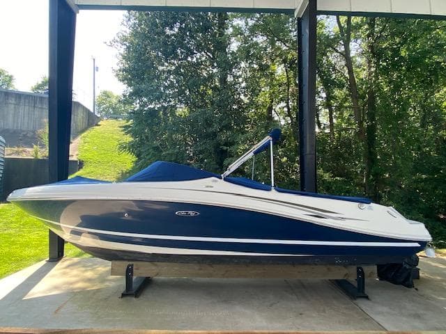 2010 Sea Ray 230 Select boat with blue and white exterior, docked under a canopy.