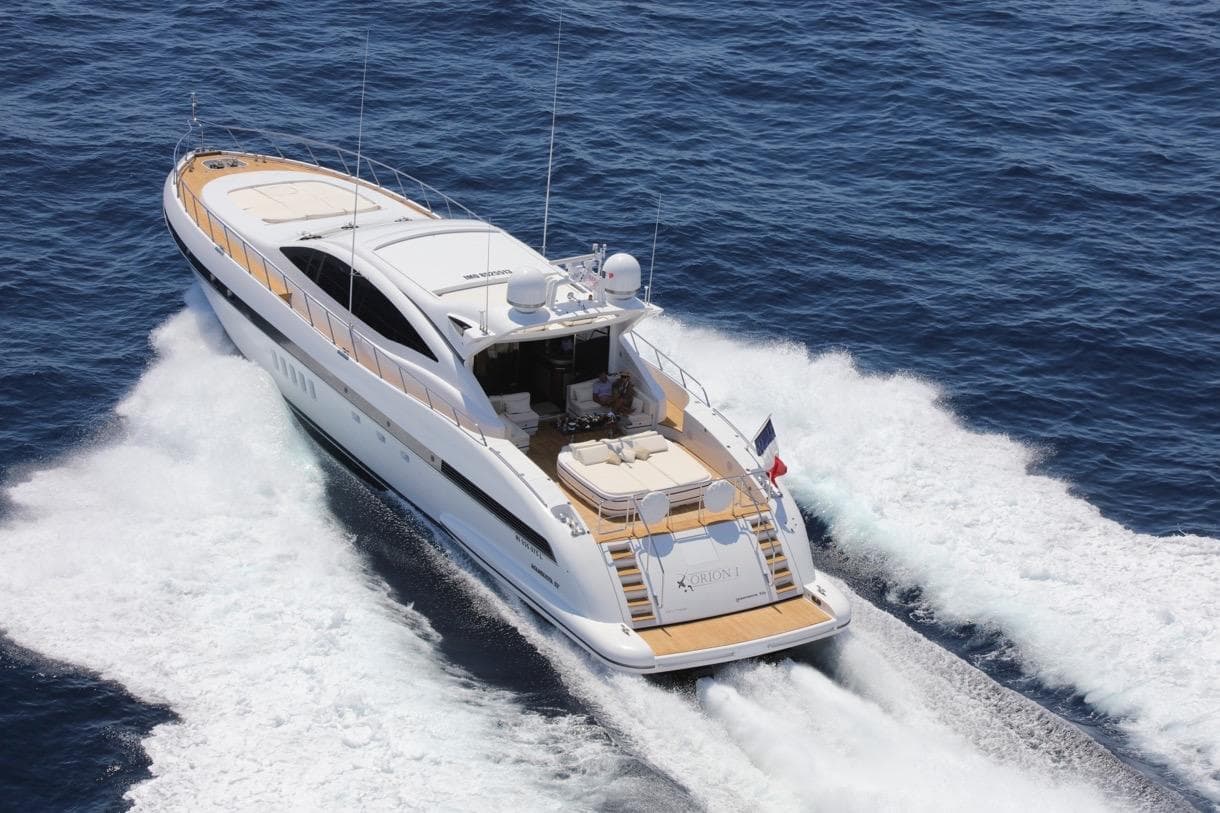 Luxurious 2009 Mangusta 92 yacht cruising on open sea, aerial view.
