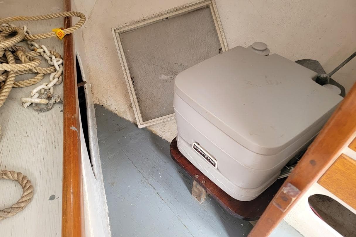 1974 Marshall 22 Catboat interior with portable toilet and coiled ropes.