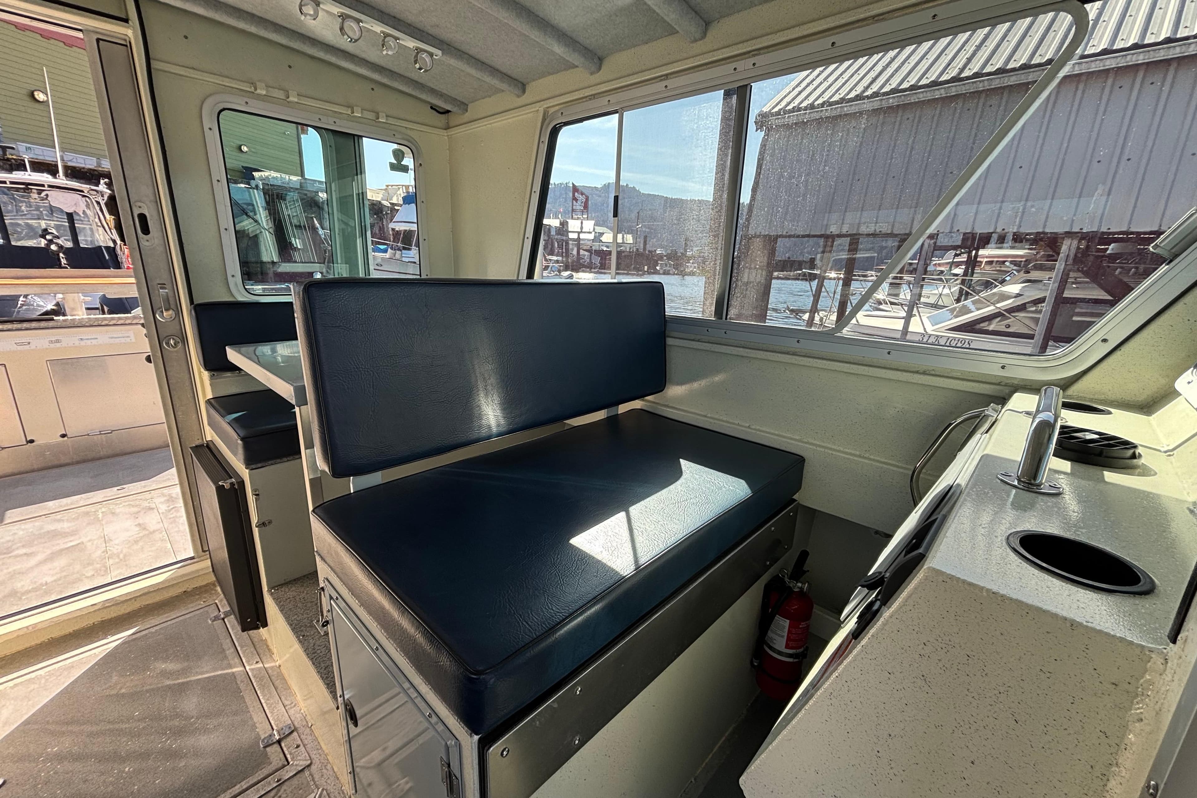 Interior of 2021 Silver Streak 32 Landing Craft Cabin, featuring seating and control panel.
