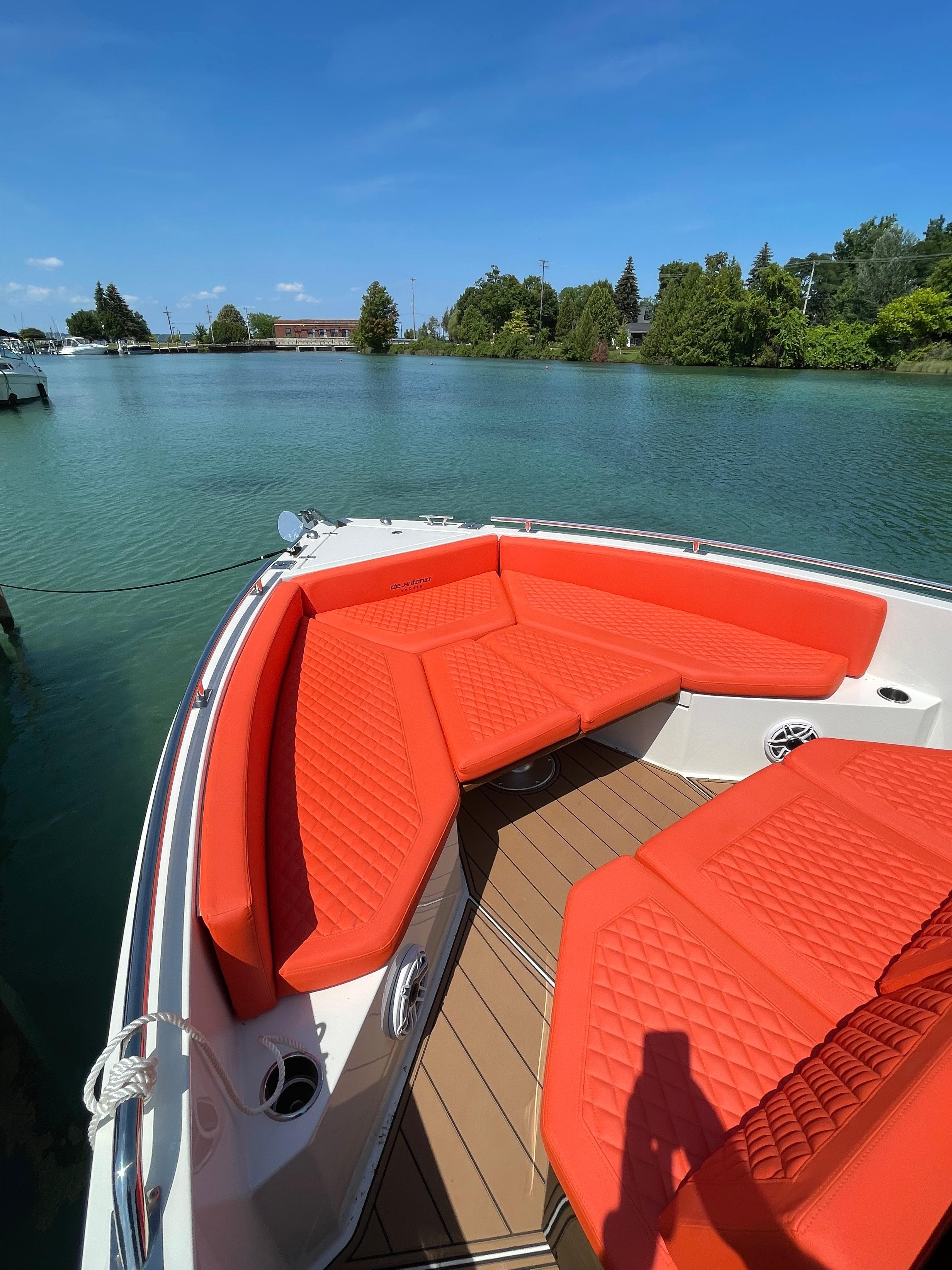 De Antonio Yachts D 28 (2020) with vibrant orange seating on a serene lake.