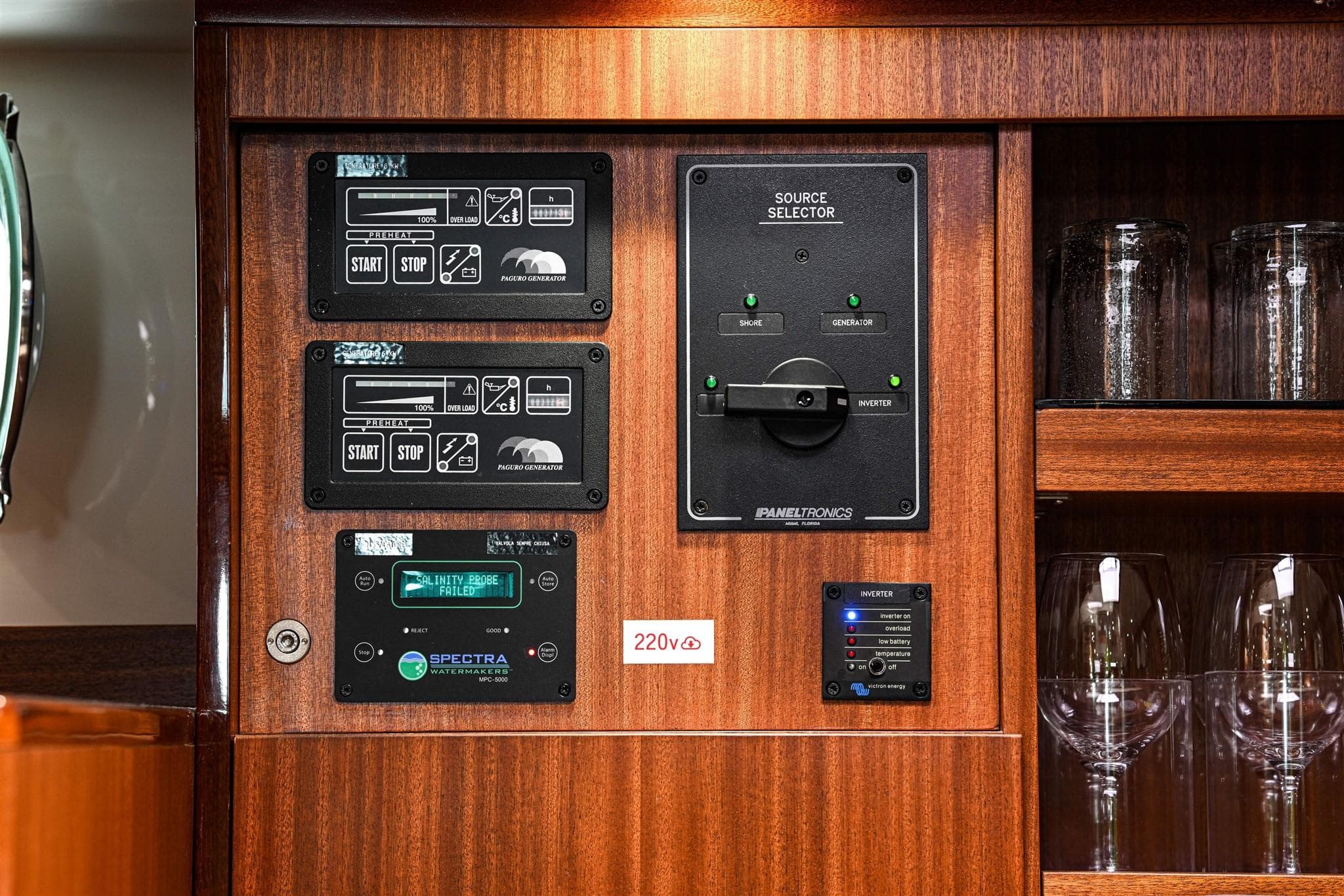 Control panel on 1978 Stain 70 Gulet yacht with wooden cabinetry and glassware.