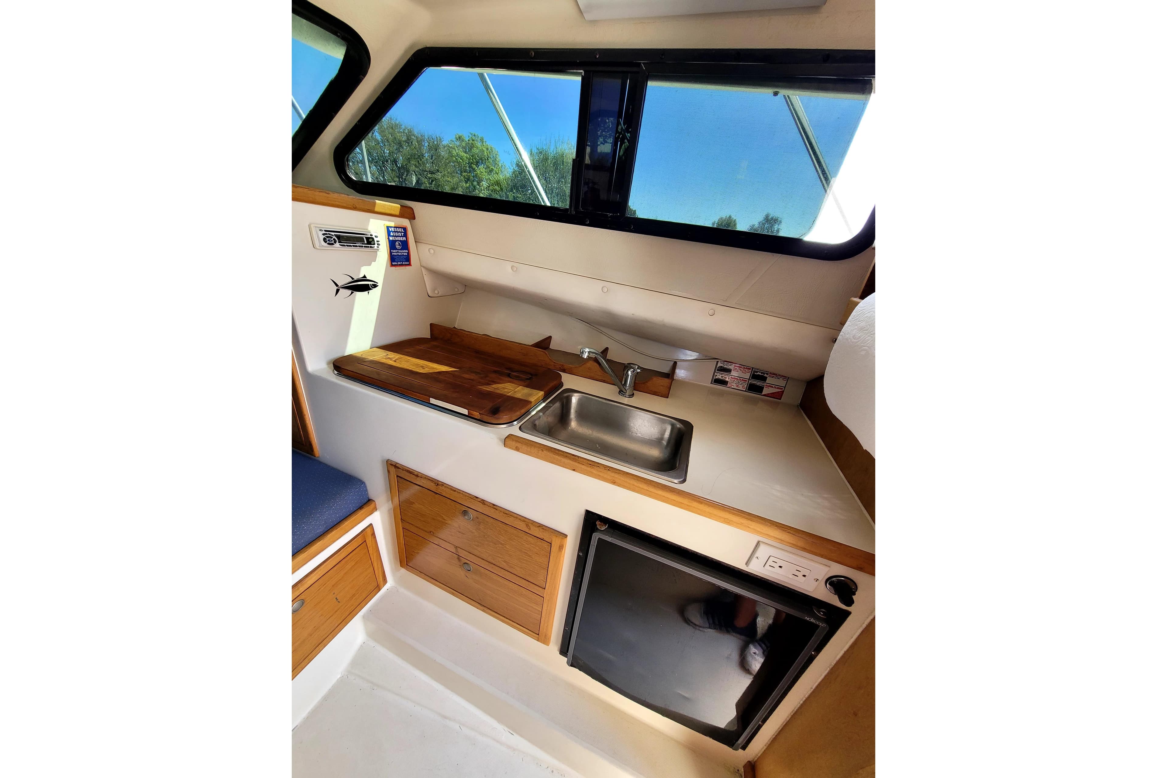 Interior of 2001 Skipjack 262 Flybridge boat with kitchenette, sink, and storage.
