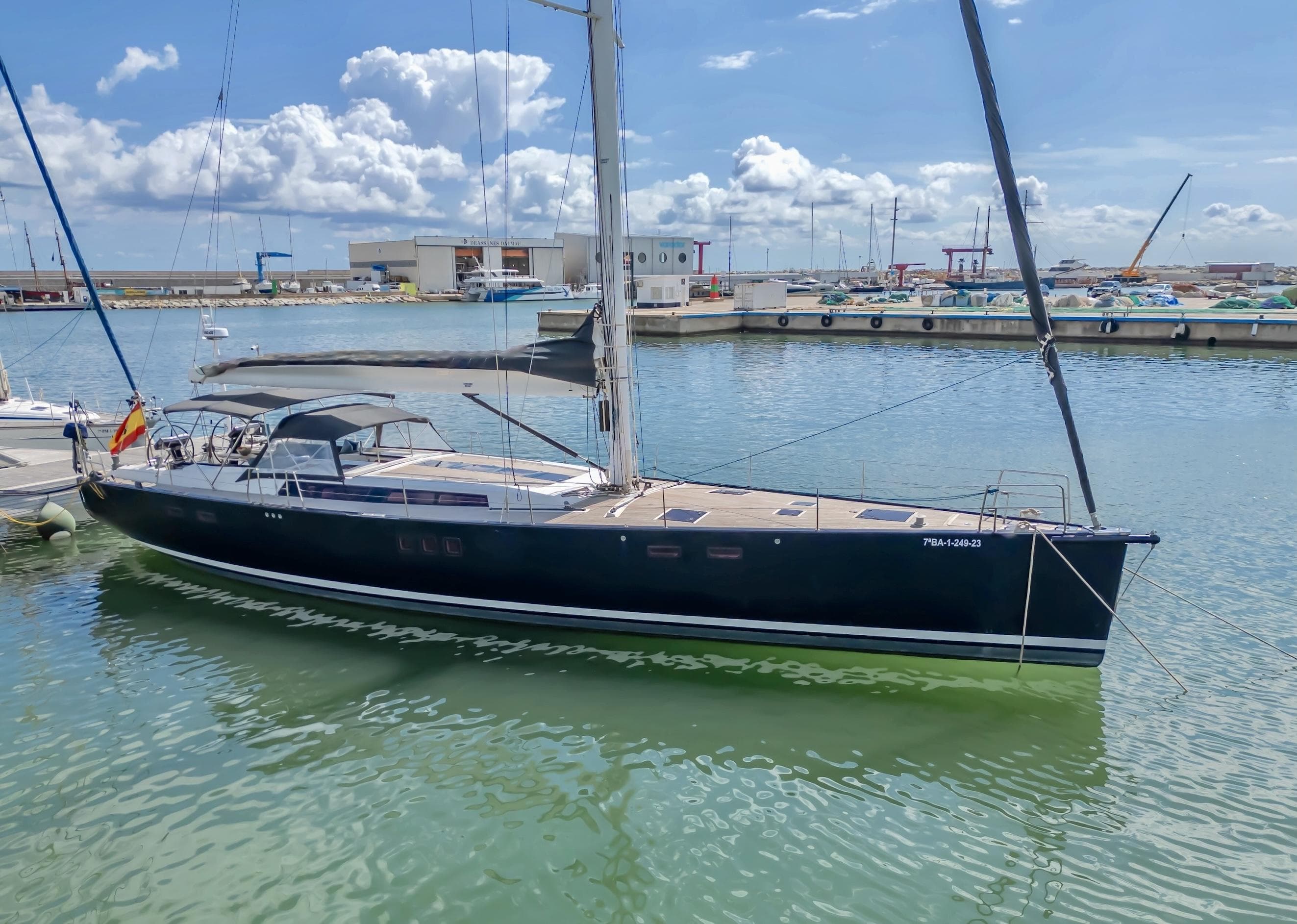 2009 Hanse 630e yacht docked in a sunny marina, clear skies above.