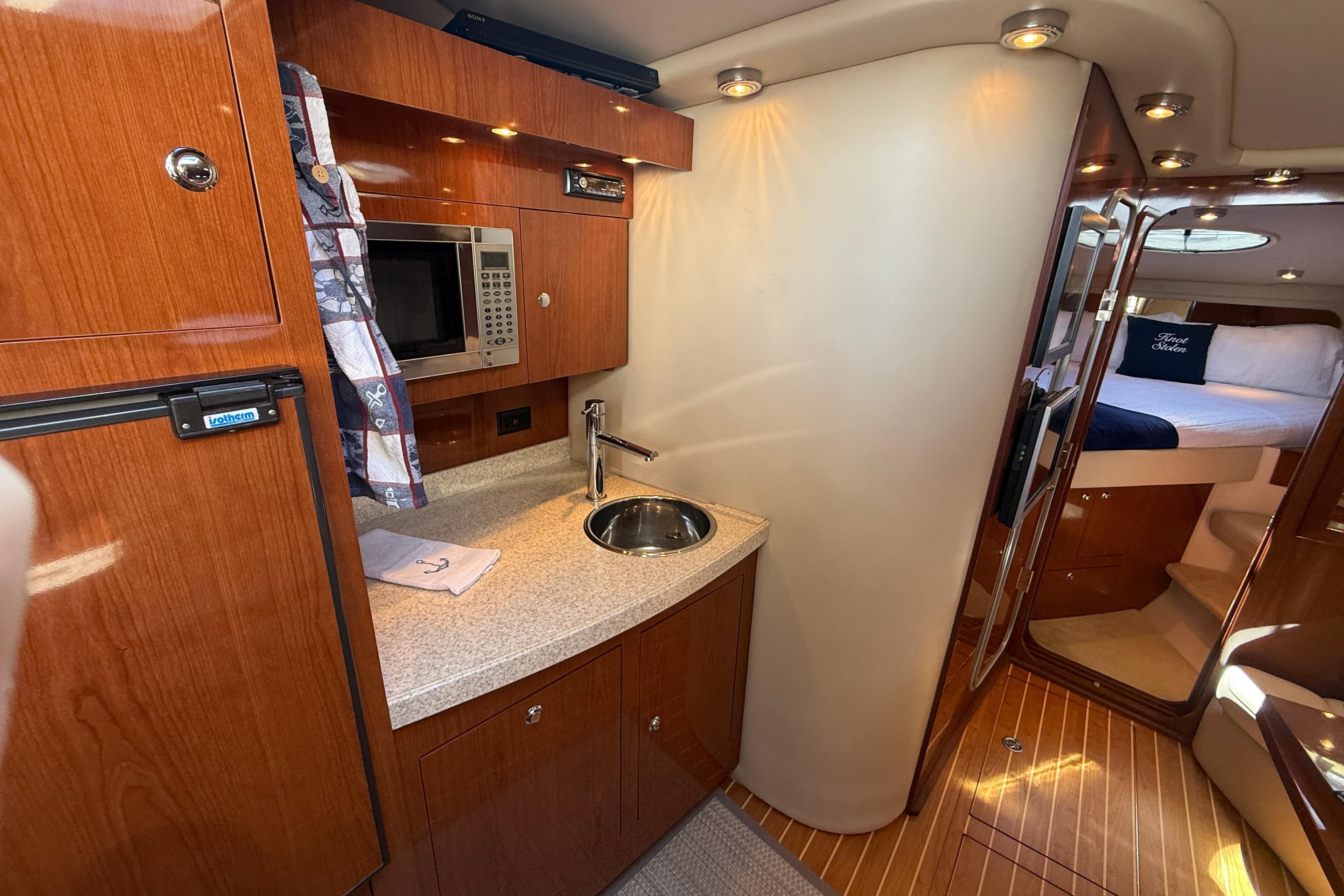 Luxurious 2006 Regal Commodore 3560 IO yacht interior with kitchenette and cozy sleeping area.