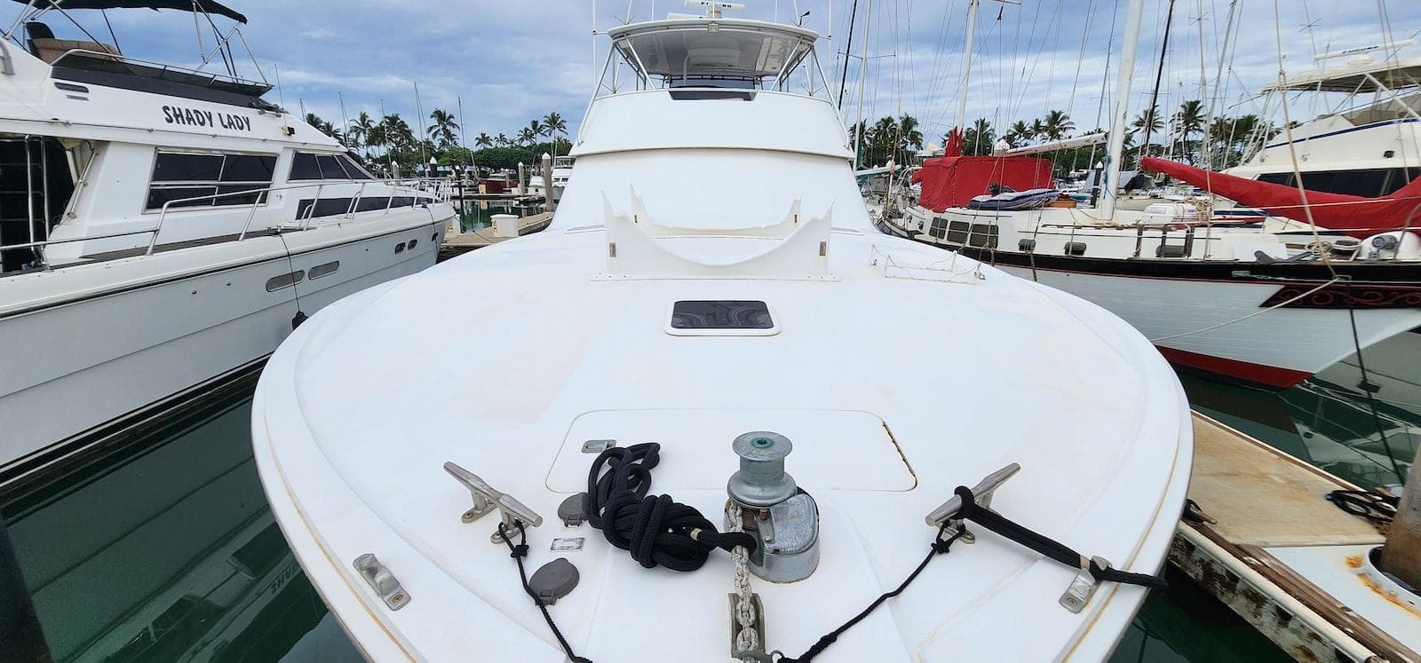 2000 Viking 55 Convertible yacht docked in marina, surrounded by other boats.