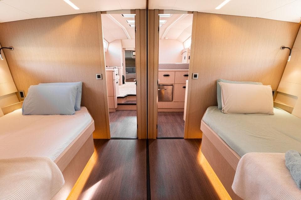Luxurious interior of 2023 Jeanneau 60 yacht with twin beds and modern design.