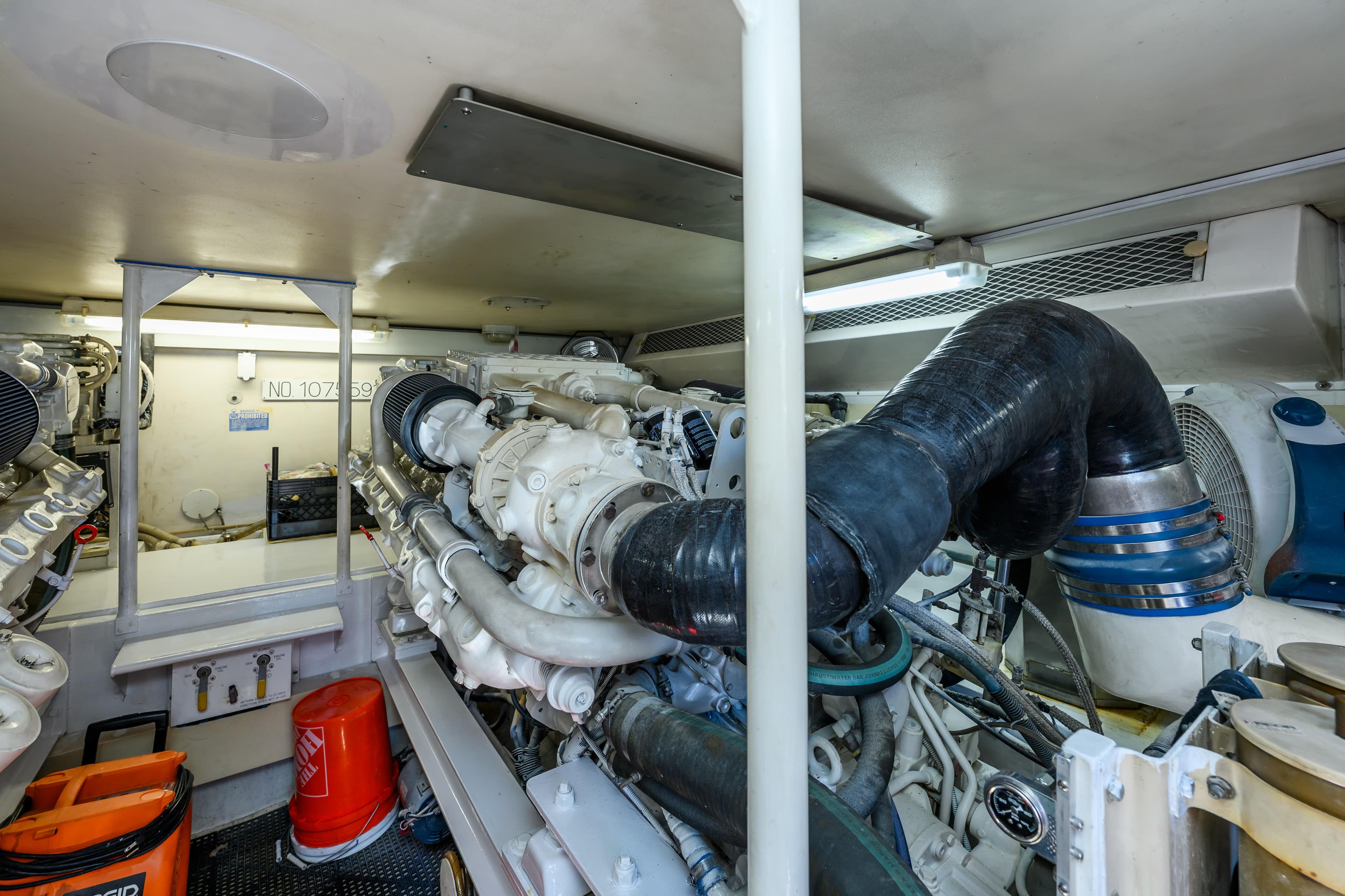 Engine room of a 1999 Viking 58 Convertible yacht, showcasing complex machinery and equipment.