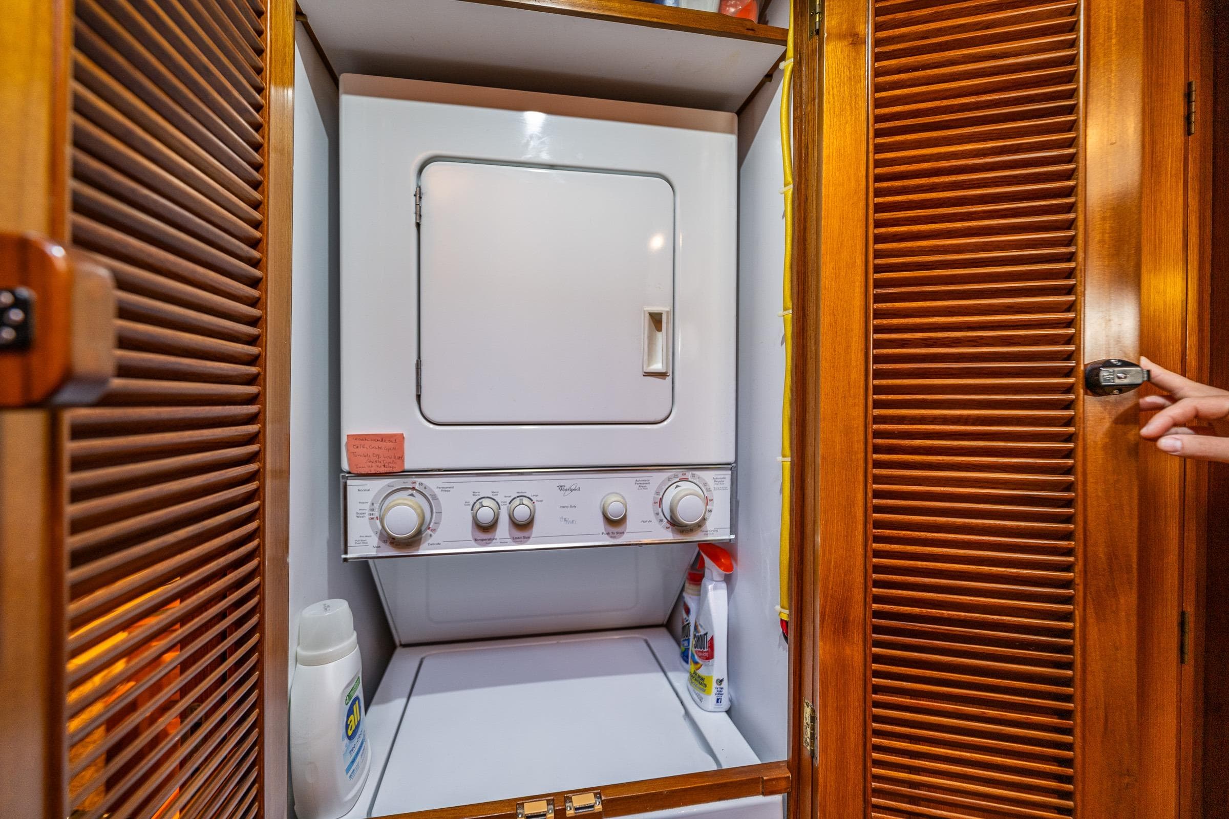Laundry area with stacked washer-dryer in 2007 DeFever 56 yacht.