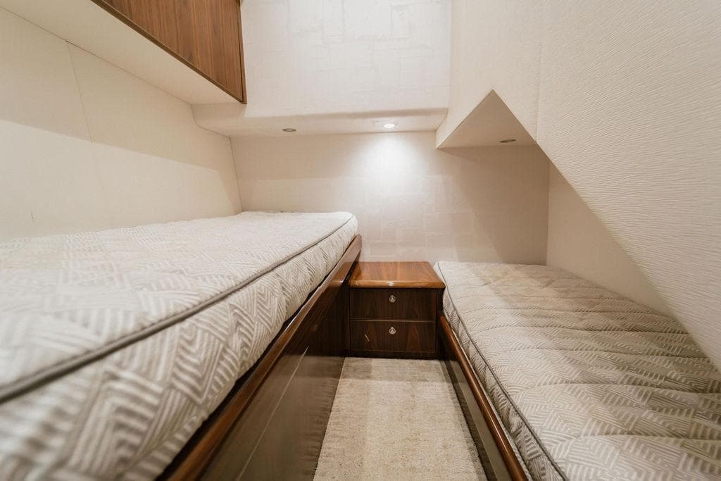 Interior of 2021 Viking 58 Convertible yacht with twin beds and wooden cabinetry.