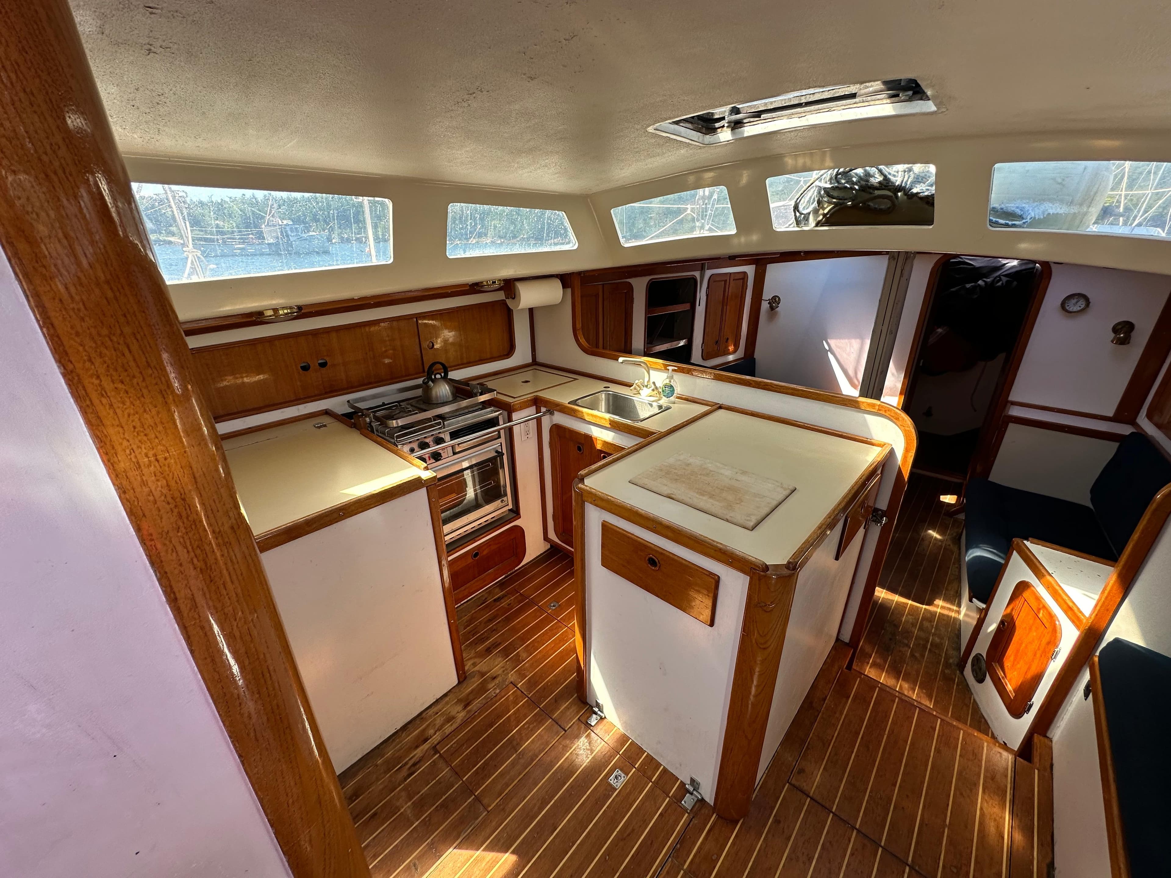 Interior of 1985 Cartwright 44 yacht with wooden cabinetry and modern kitchen amenities.