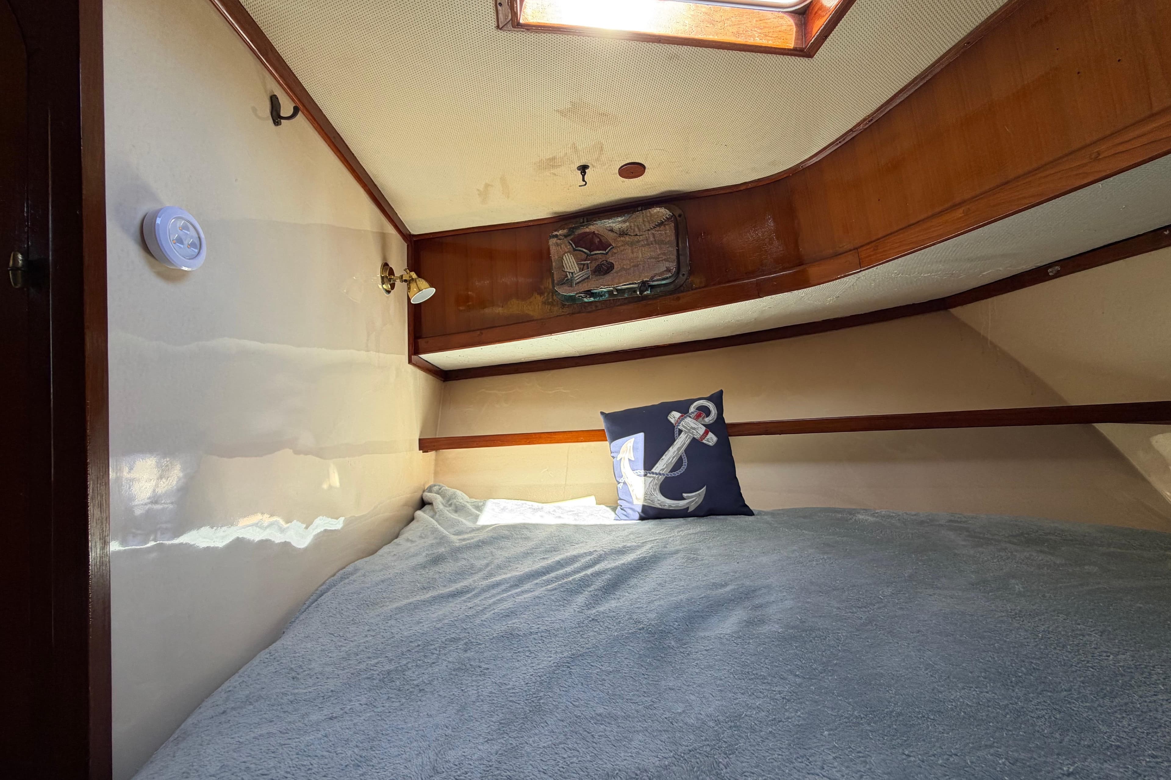 Cozy cabin interior of 1982 Lien Hwa 31 boat with anchor-themed pillow.
