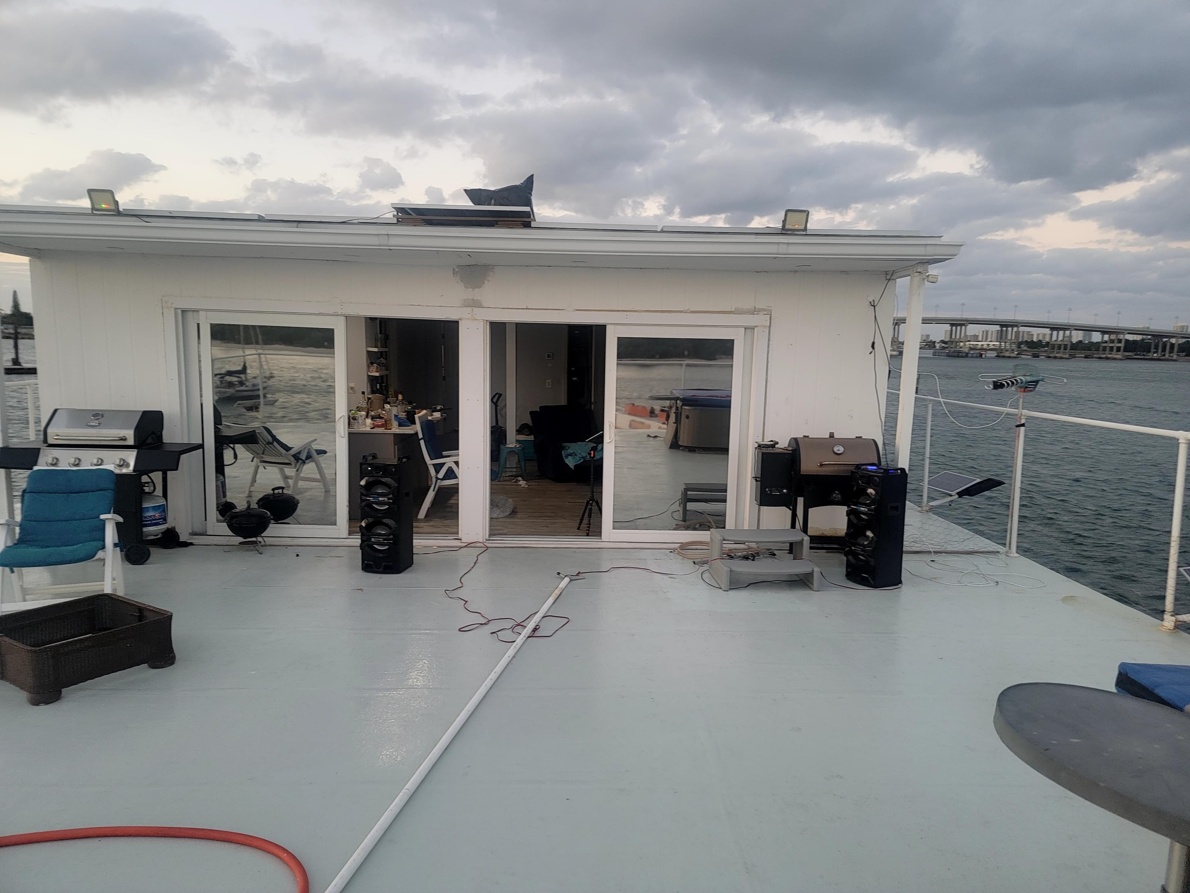 Floating home with spacious deck, grills, and ocean view under cloudy sky. Custom model, 2003.