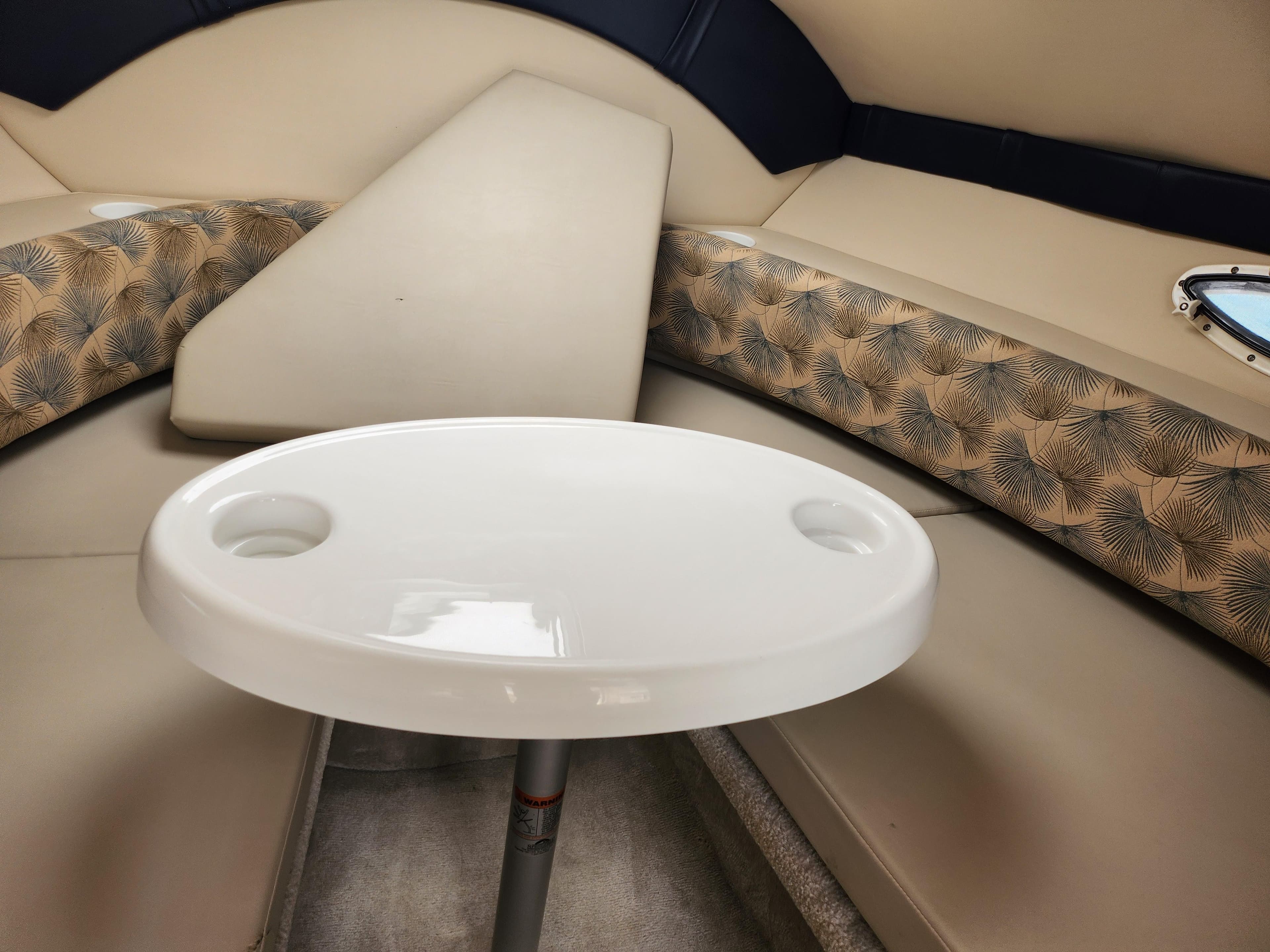 Interior seating area of 2008 Glastron GT 249 boat with table and cushioned seats.