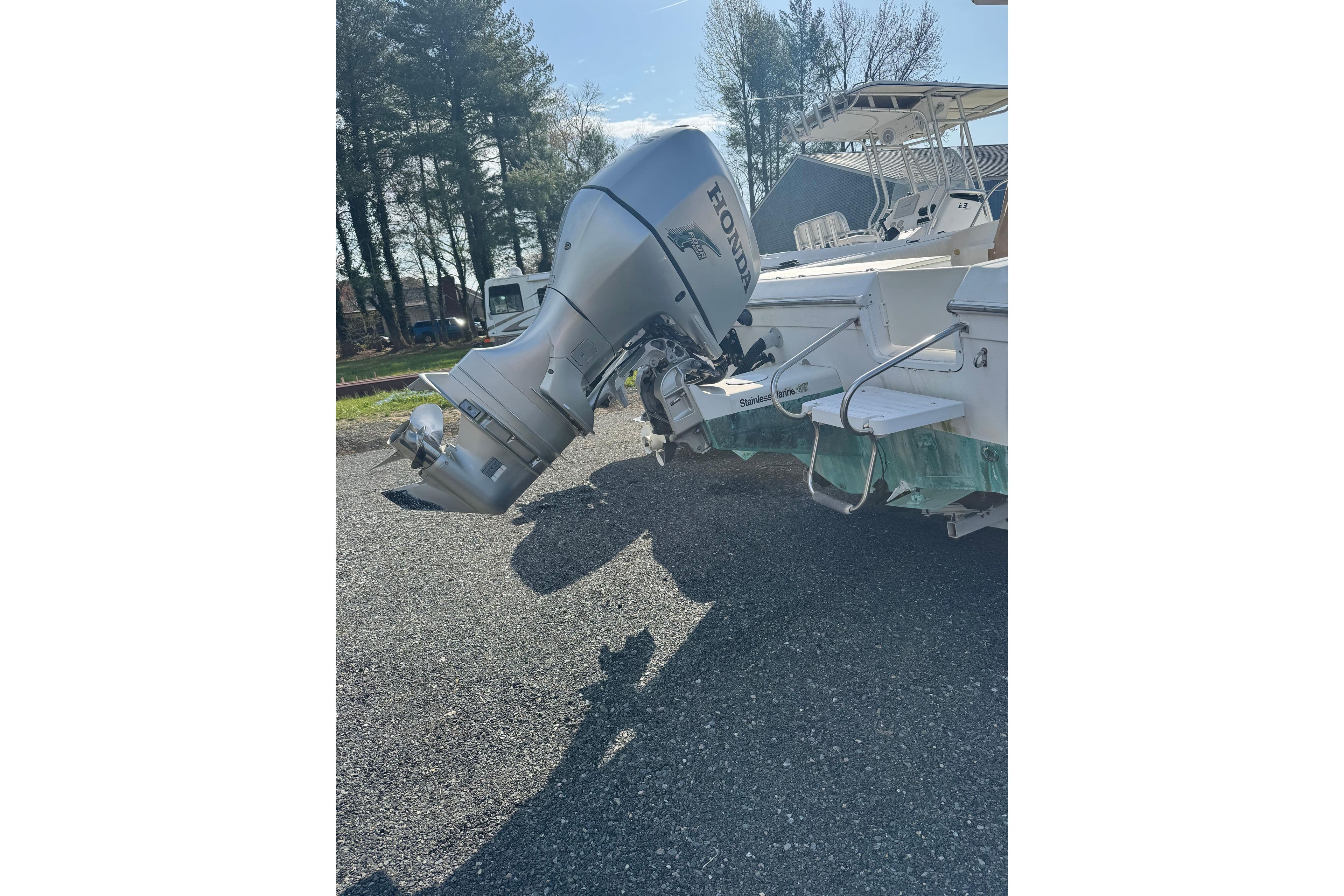 2000 Sport-Craft 241 Walk Around boat with Honda outboard motor in a sunny outdoor setting.