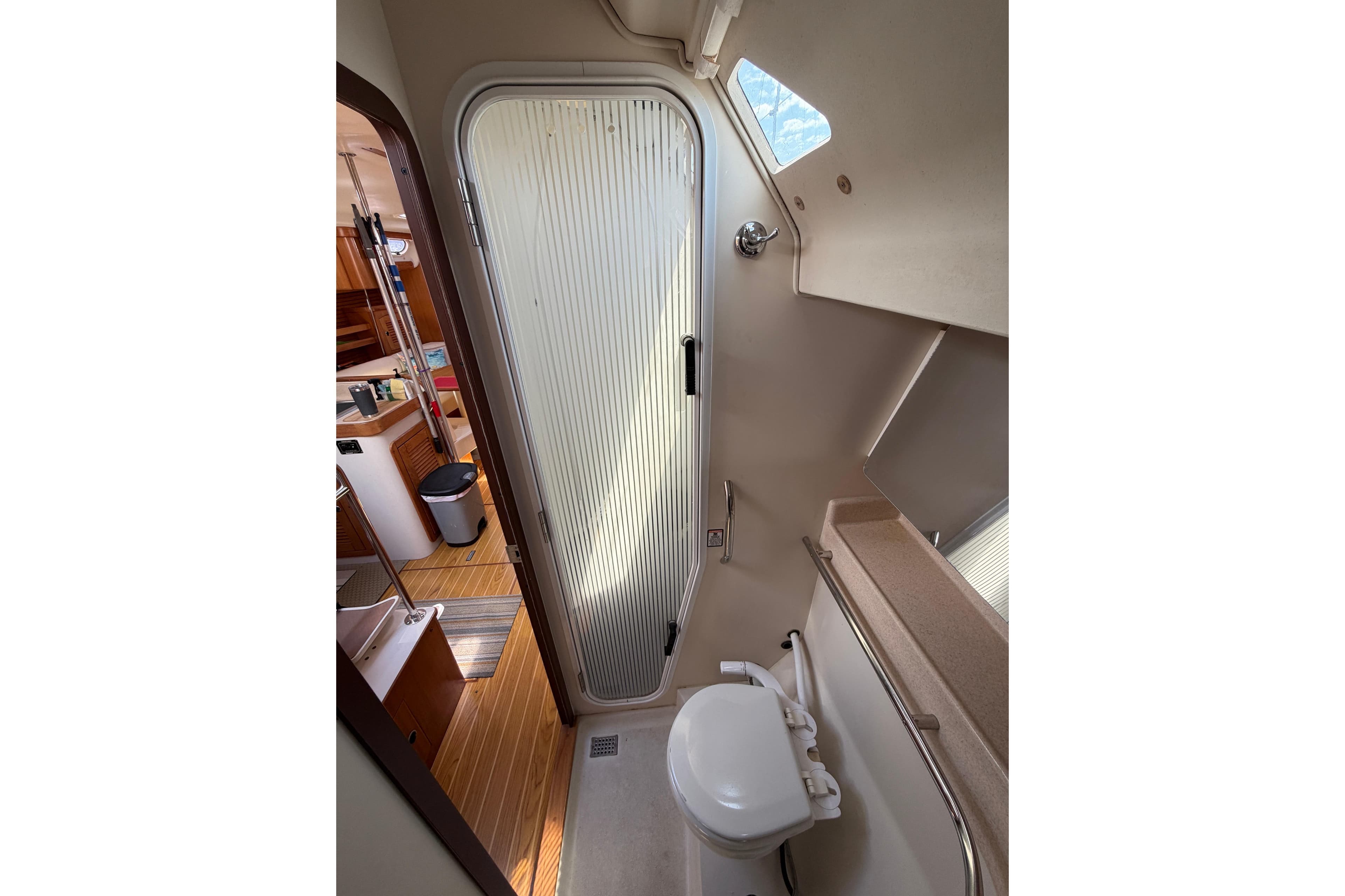 Interior of 2002 Catalina 470 yacht bathroom with toilet and shower door.