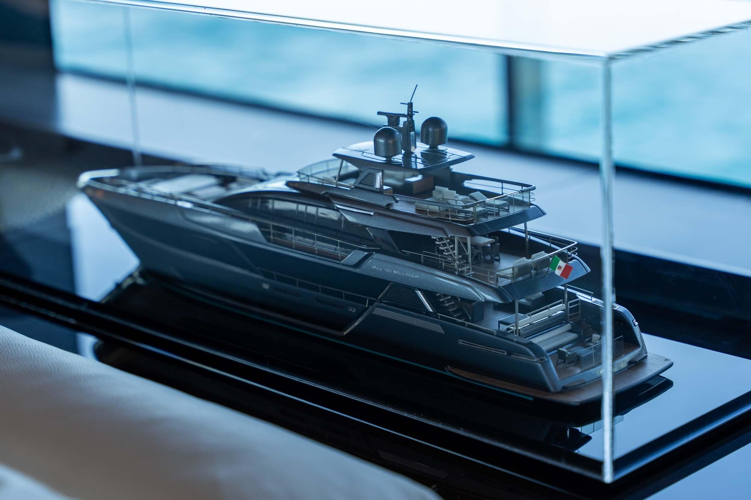 Model of 2023 Riva 130' Bellissima yacht displayed in a glass case.