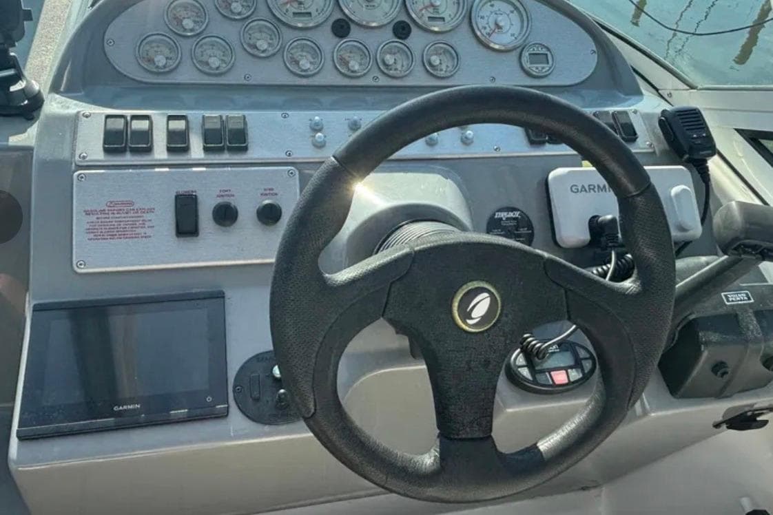 Steering console of 2005 Cruisers Yachts 280 CXi Express with gauges and Garmin device.