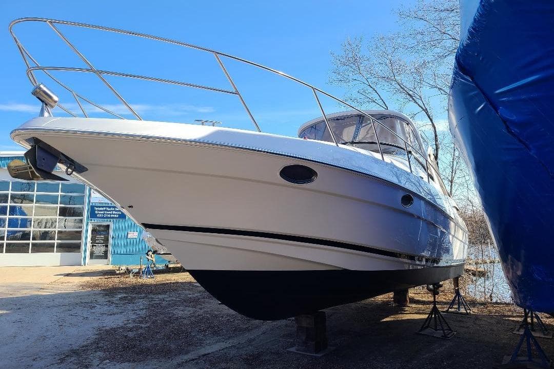 2009 Regal Commodore 3760 IB boat on stands, outside a blue building.