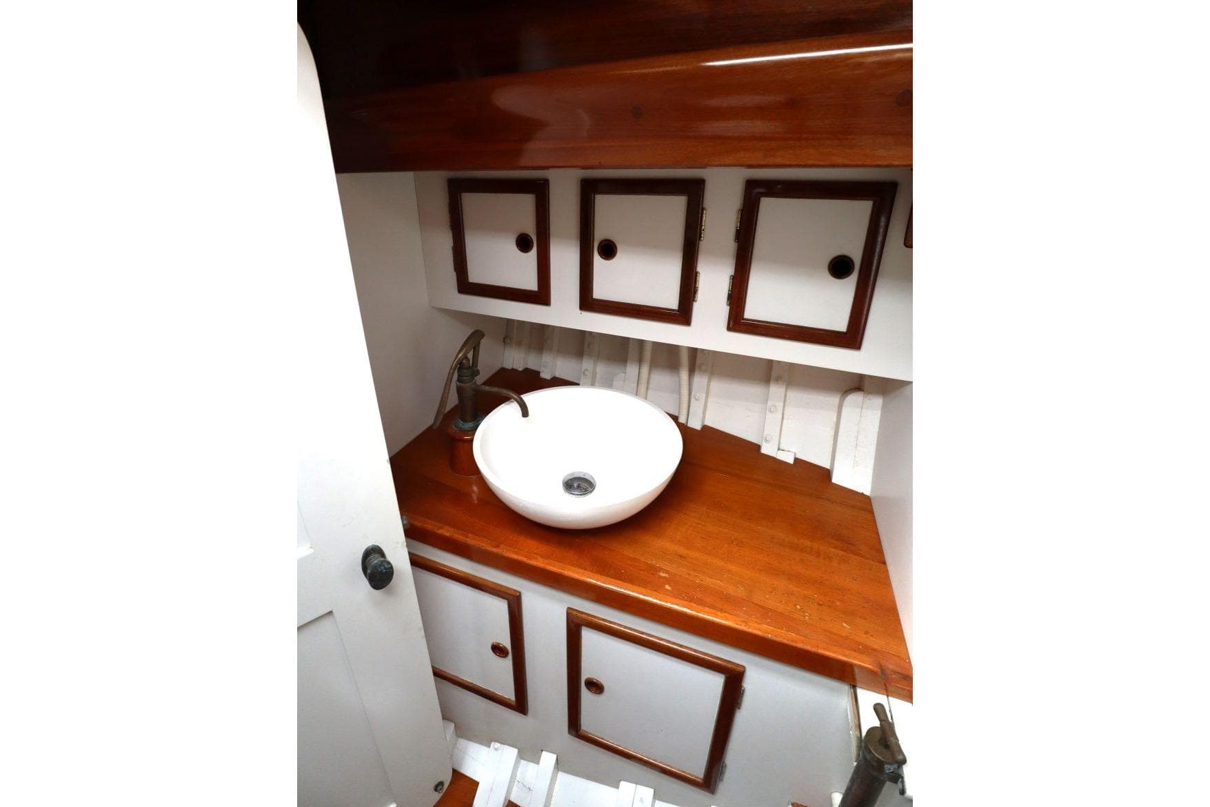 1939 Classic Custom boat interior with wooden cabinets and a modern round sink.