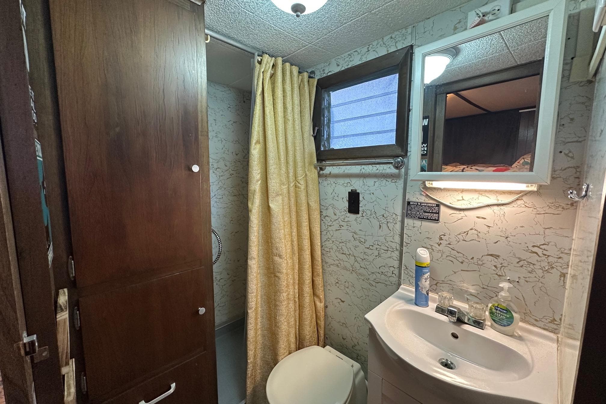 Compact 1966 Lazy Days RV bathroom with shower, sink, and storage cabinet.