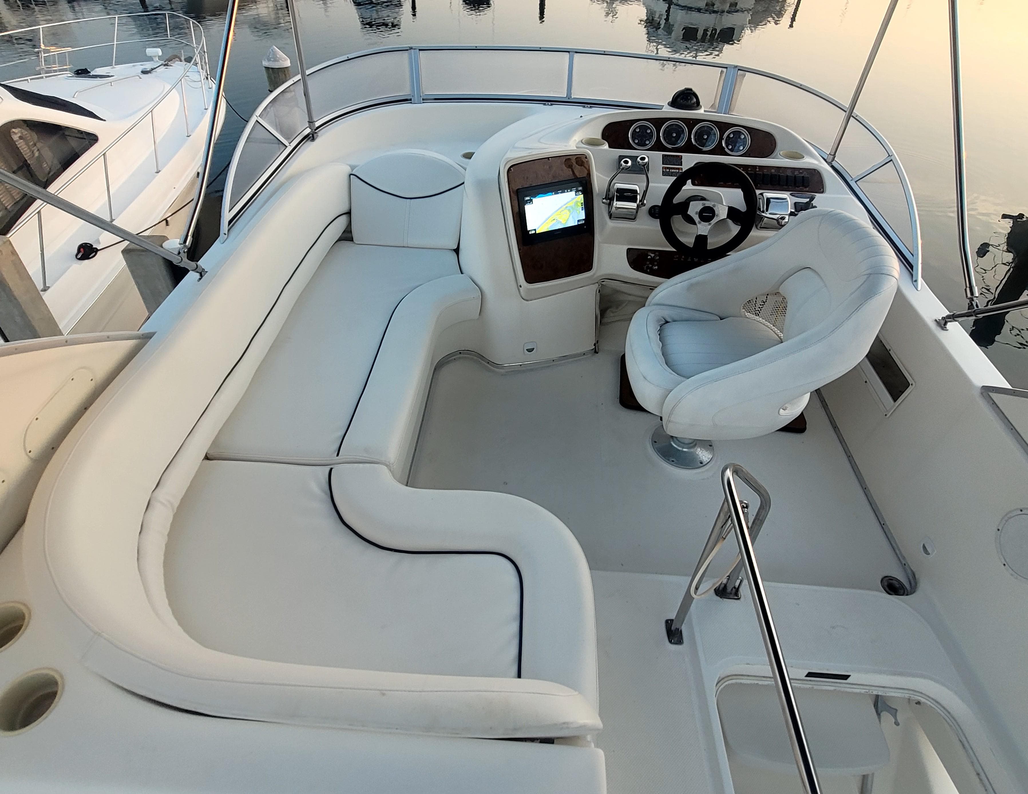 2004 Meridian 341 Sedan boat cockpit with white seating and modern controls.