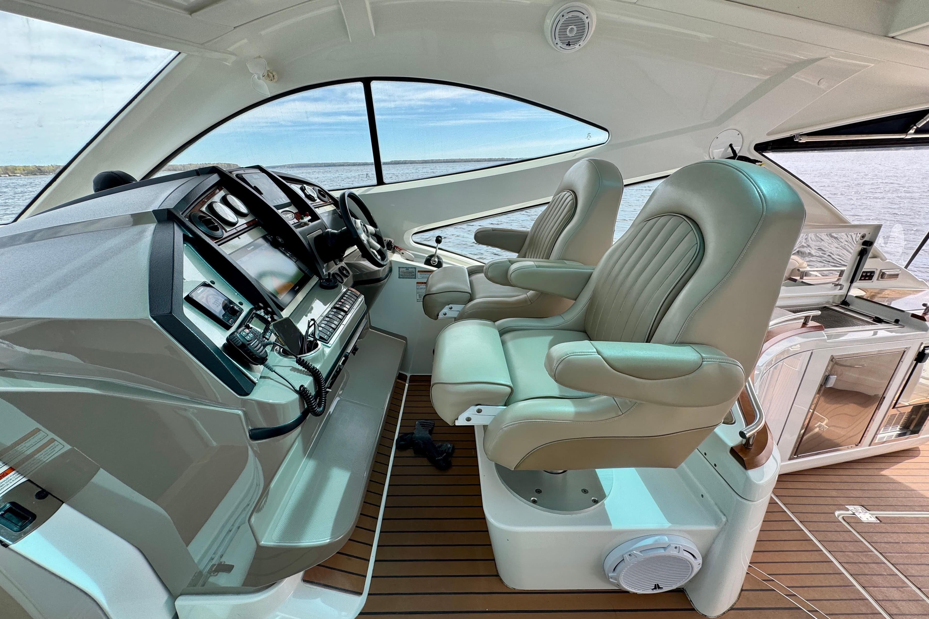Luxurious helm of 2009 Cruisers Yachts 520 Sports Coupe with leather seats and modern controls.