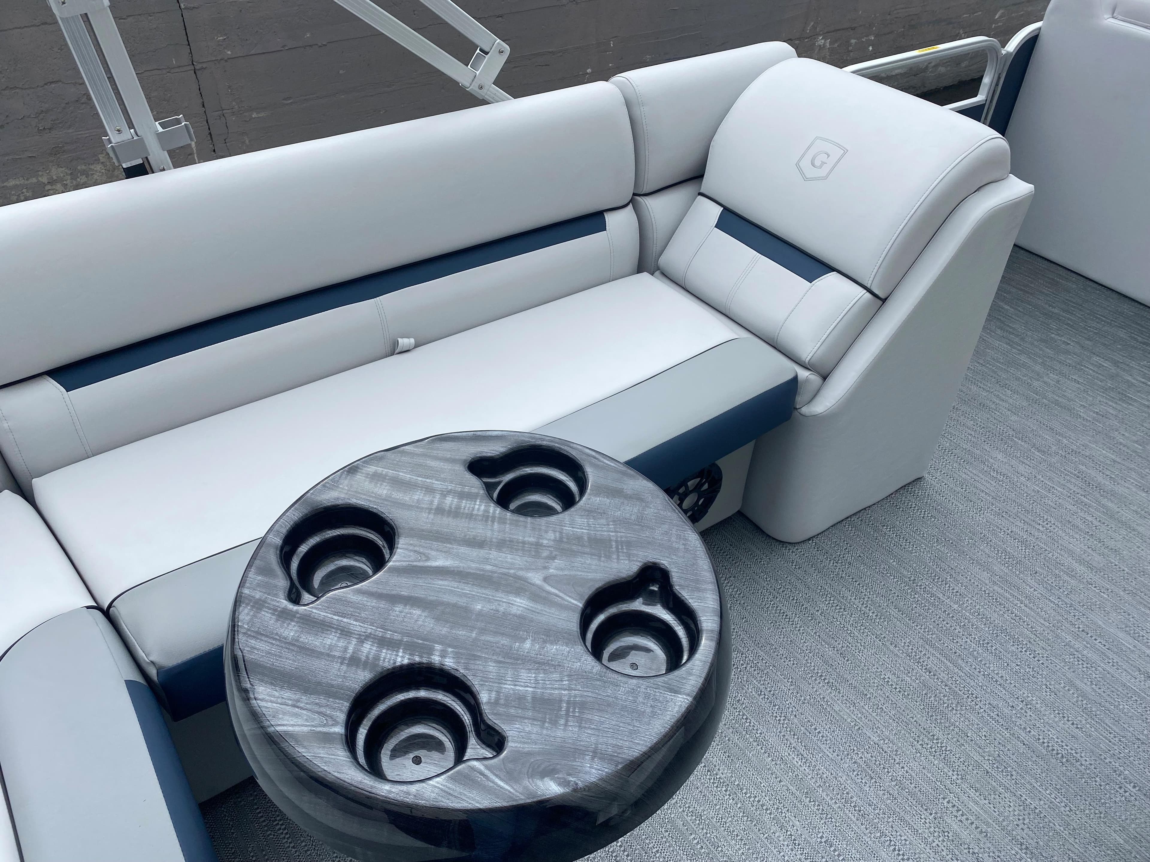 2022 Godfrey Sweetwater 2186 C4 boat interior with cushioned seating and cup holder table.