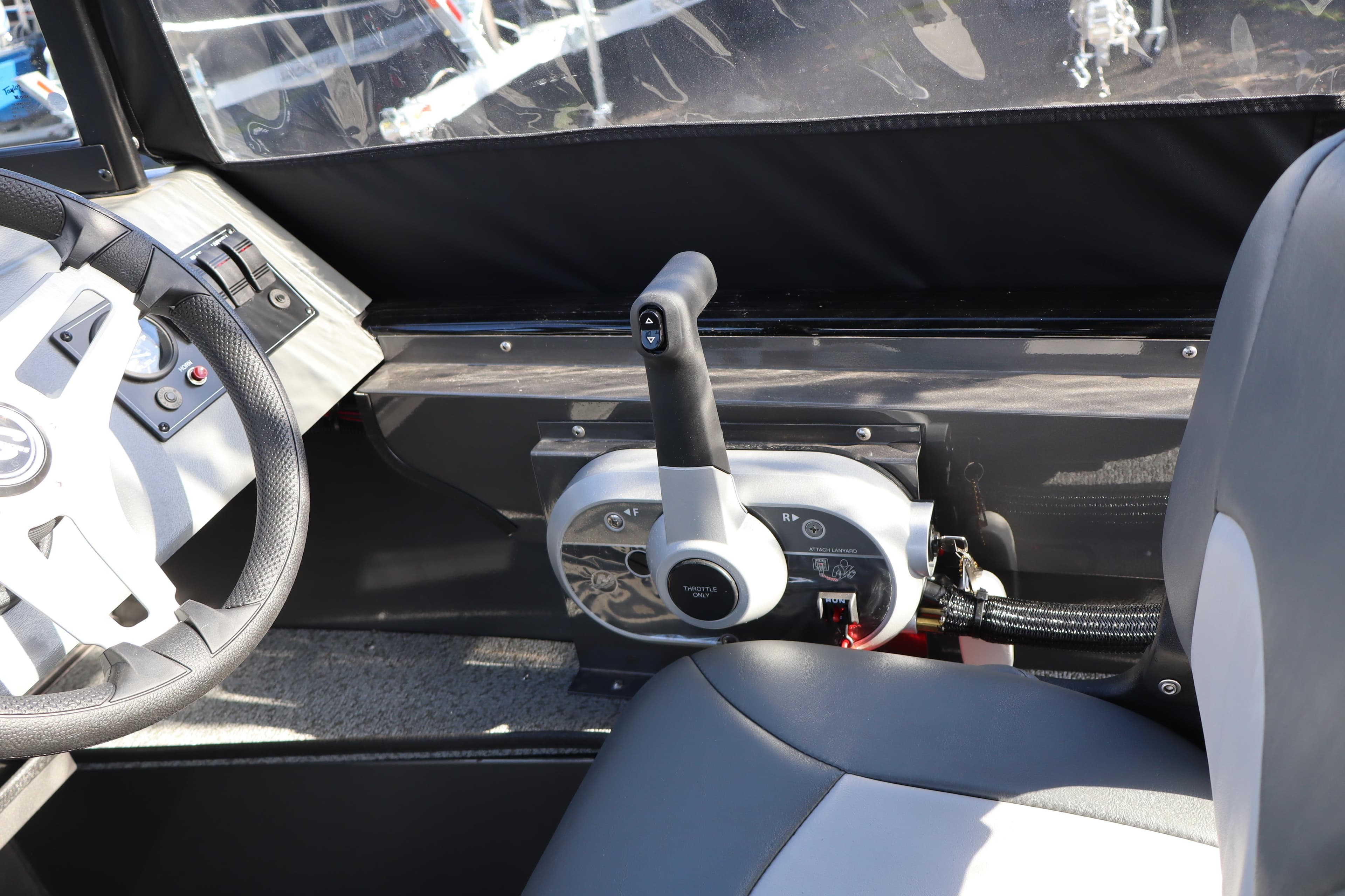 Interior of 2026 Smoker Craft Pro Tracer 162 boat, featuring steering wheel and throttle controls.