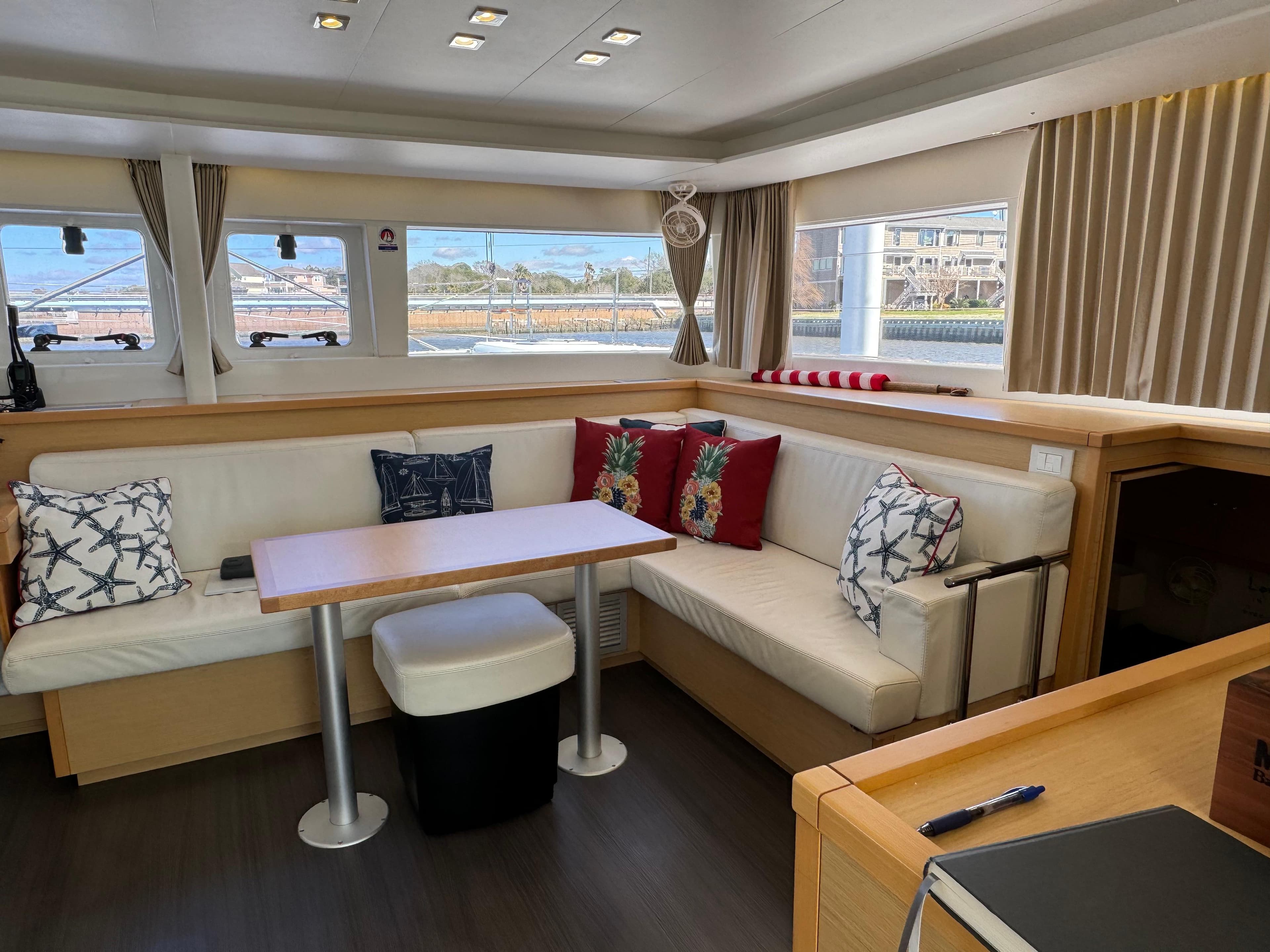 Interior of 2016 Lagoon 450 catamaran with cozy seating and nautical-themed decor.