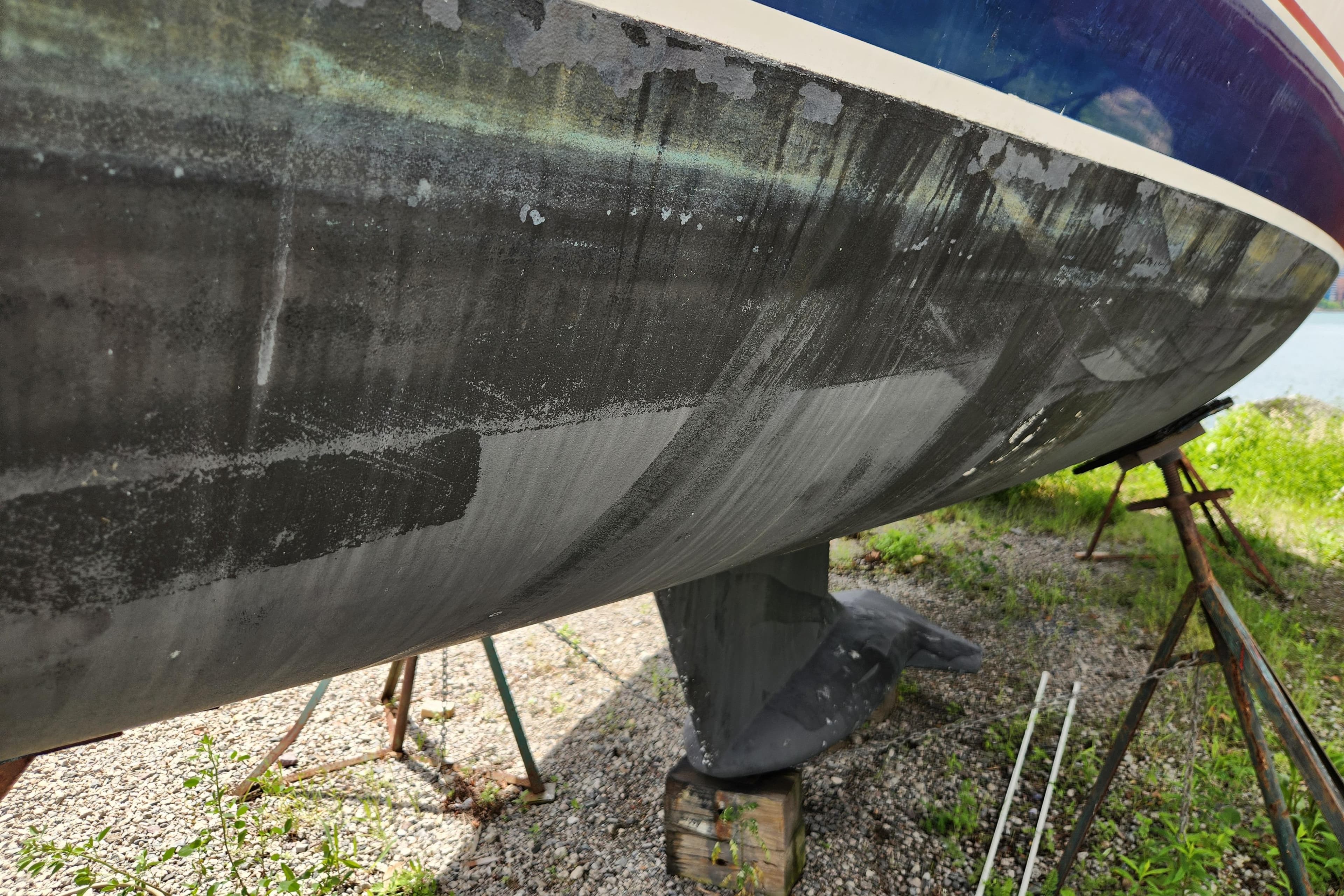 1997 Hunter 340 sailboat hull on stands, showing wear and weathering.