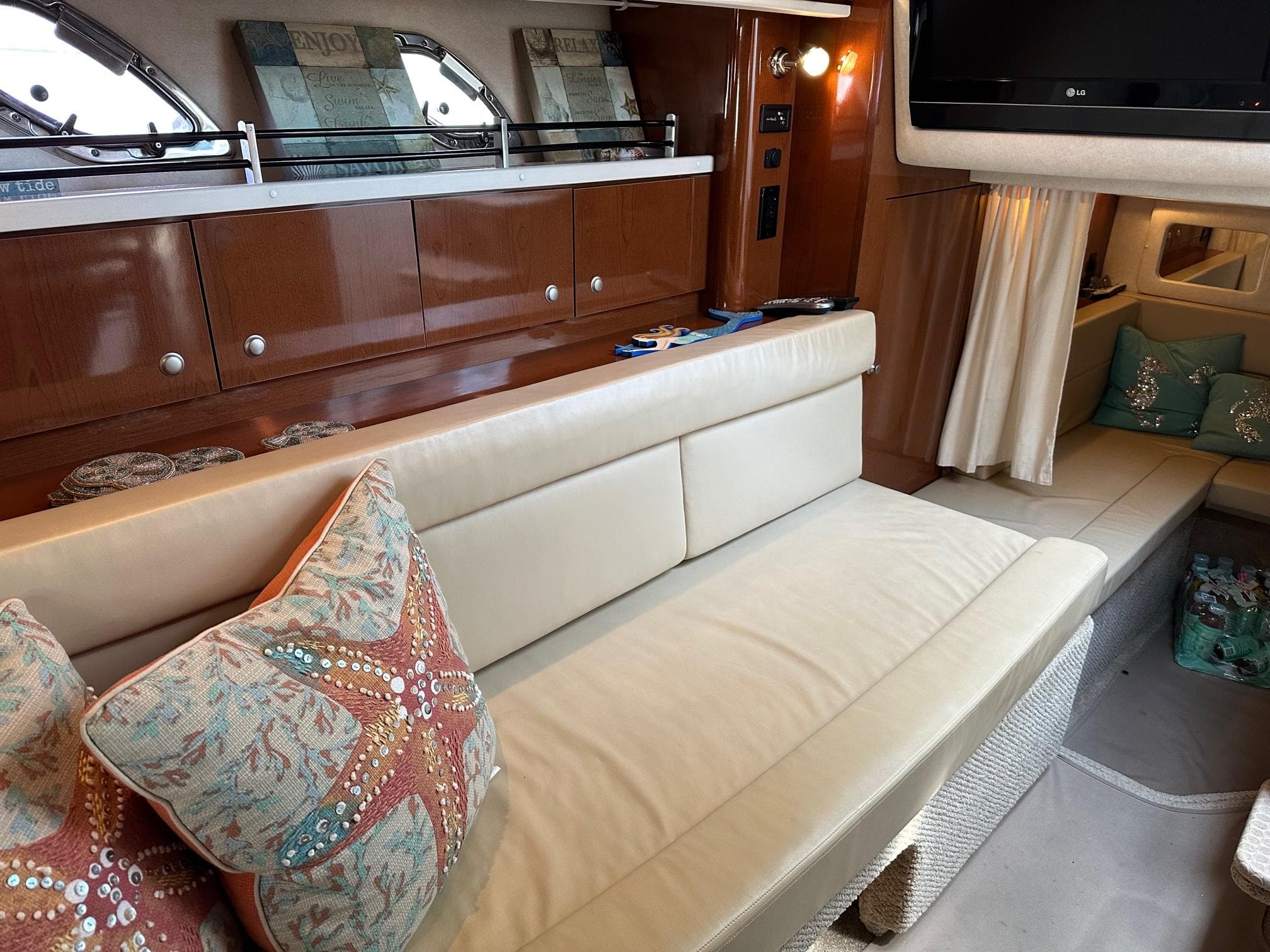 Interior of a 2008 Sea Ray 330 Sundancer with beige leather seating and starfish-themed pillows.