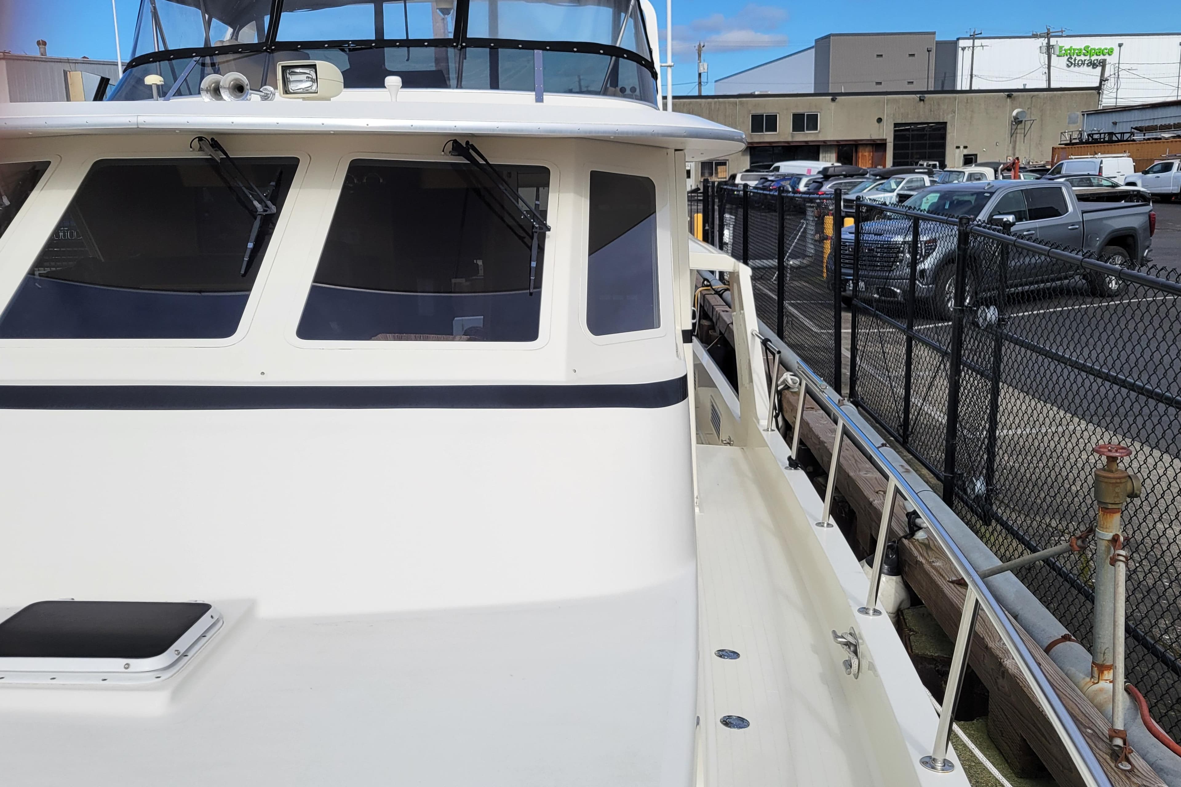 1998 Tollycraft 65 Pilothouse yacht docked, showcasing sleek design and spacious deck.