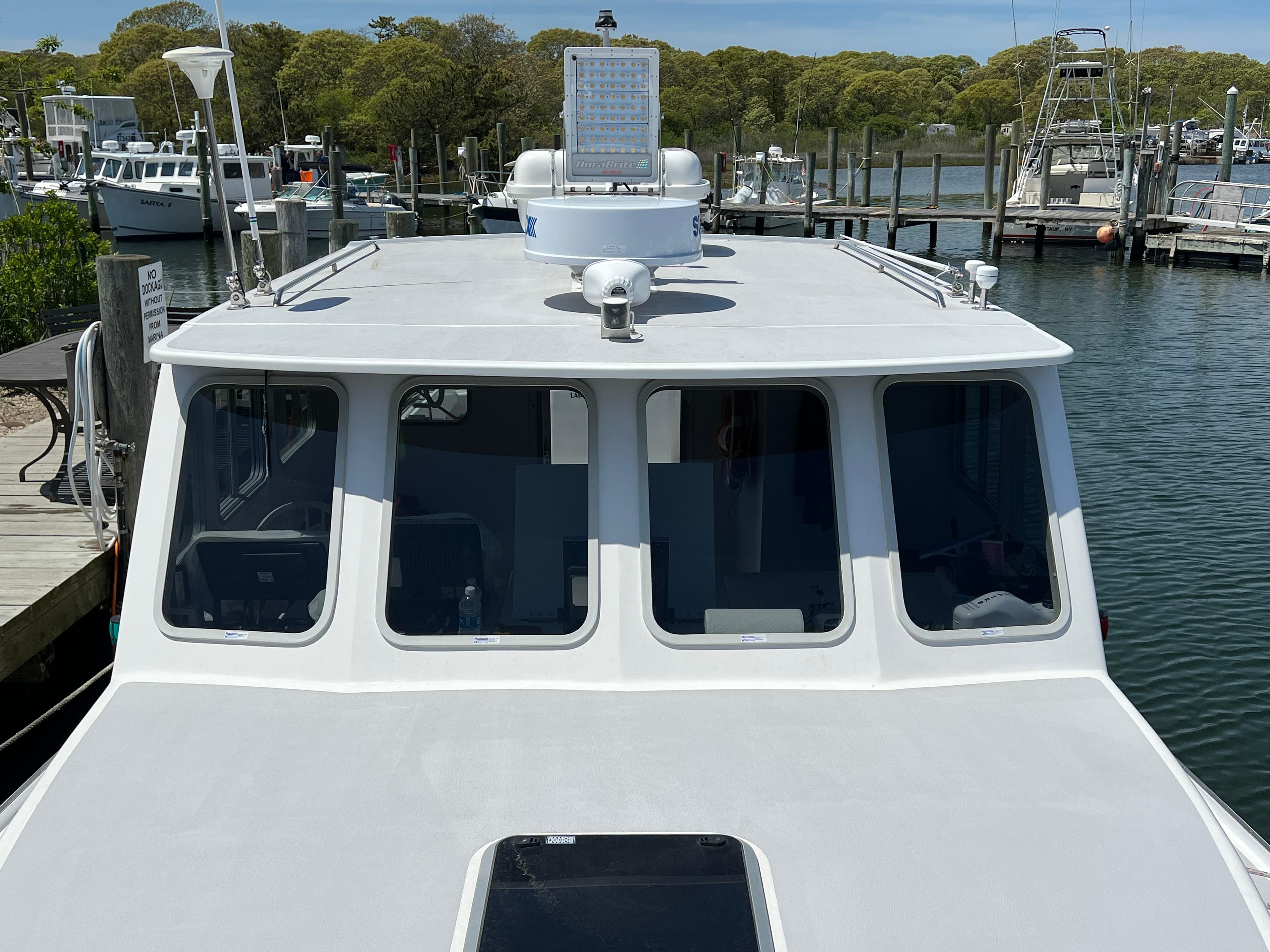 2022 Wesmac 38 boat docked at a marina, showcasing its cabin and deck.
