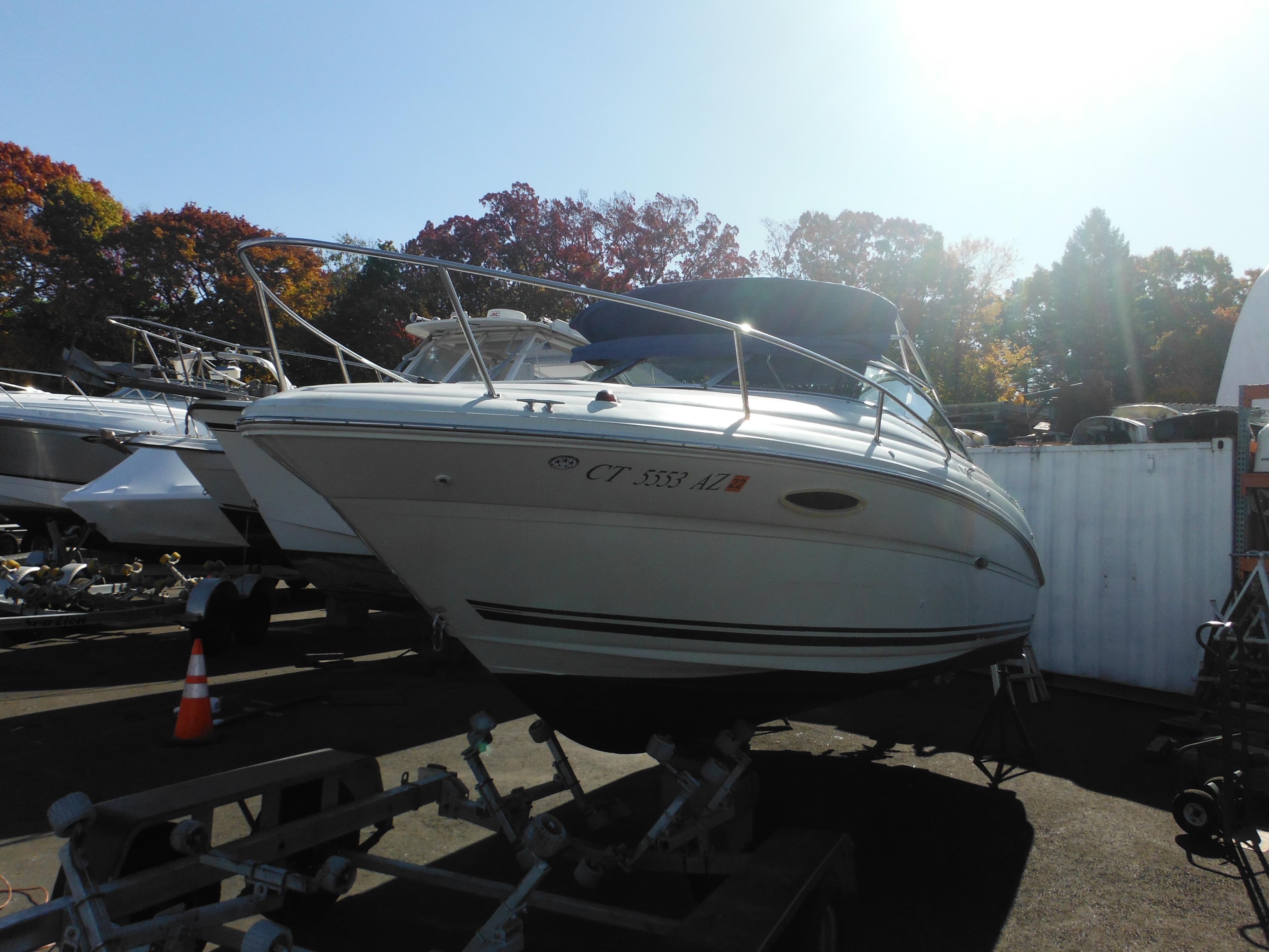 2004 Sea Ray 215 Weekender boat on trailer in sunny outdoor setting.