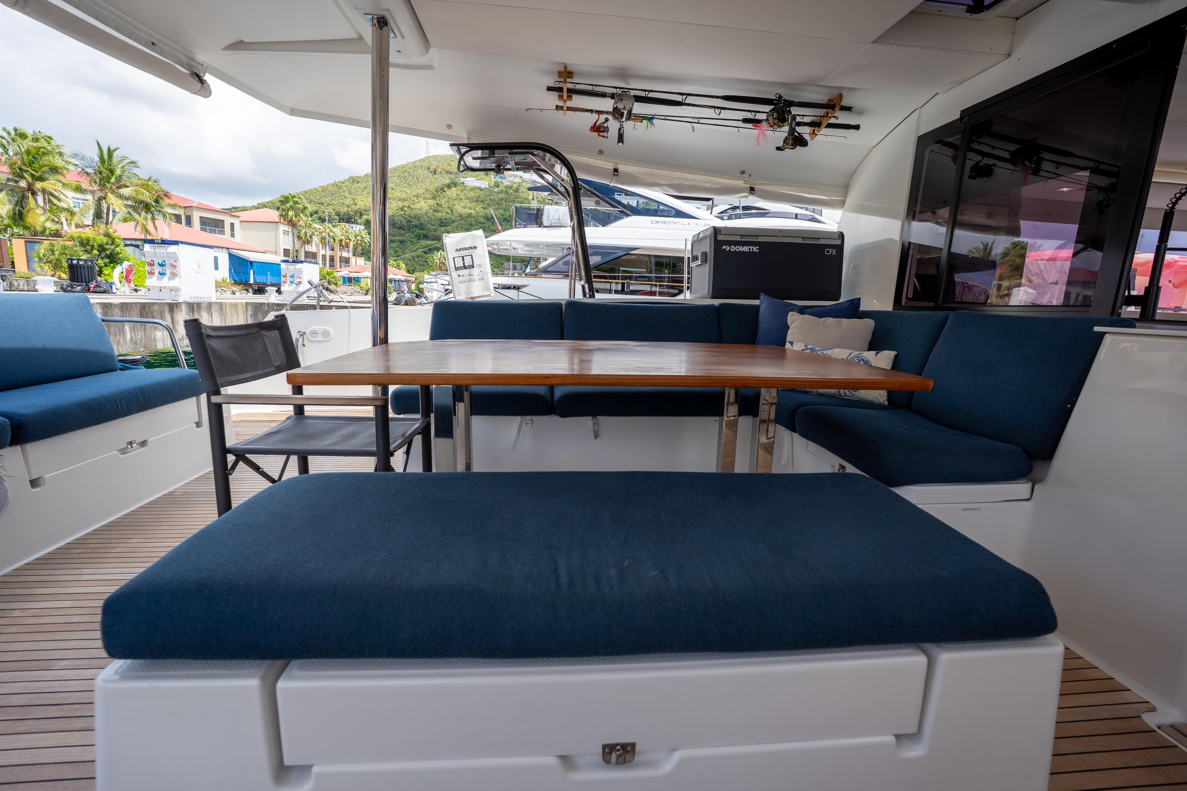 Spacious outdoor seating on 2020 Fountaine Pajot SABA 50 catamaran with blue cushions and wooden table.