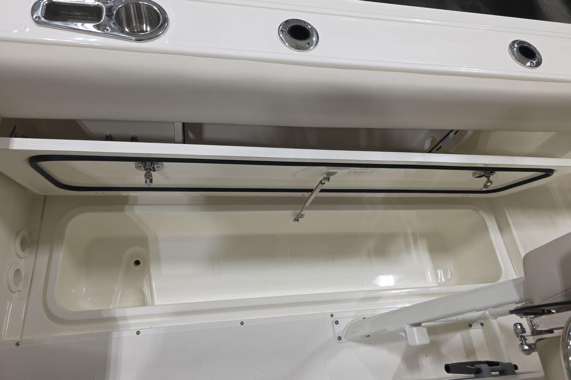 2026 Boston Whaler 230 Outrage boat storage compartment with open hatch.